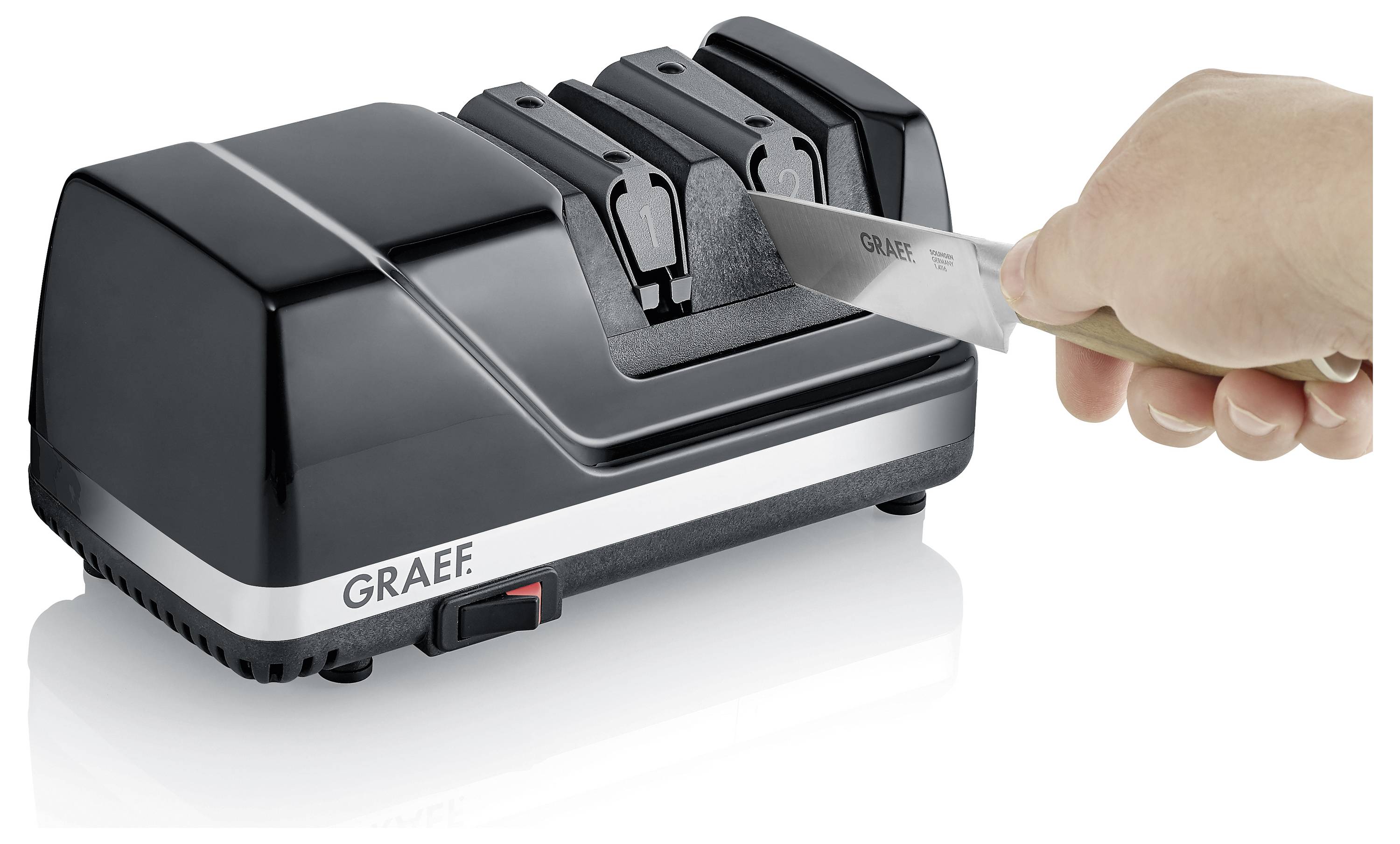 Elektrischer Messerschärfer in Betrieb, der eine Messerklinge schärft. Das Gerät ist schwarz mit silbernen Akzenten und trägt die Aufschrift 'GRAEF'.