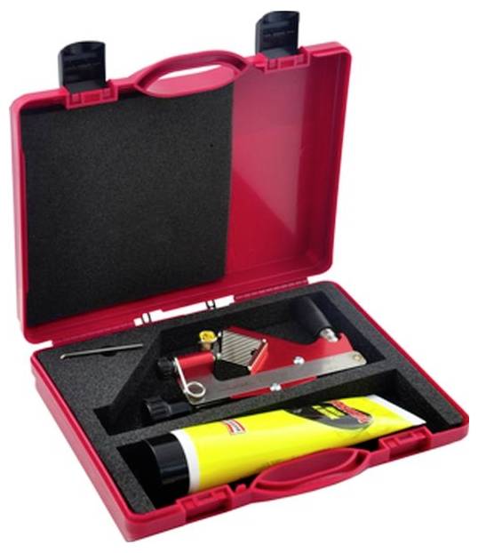 Rote Plastikbox mit einer gelben Tube, einem metallenen Dreiecks-Werkzeug und einem kleinen Schraubendreher auf schwarzer Schaumstoffpolsterung.