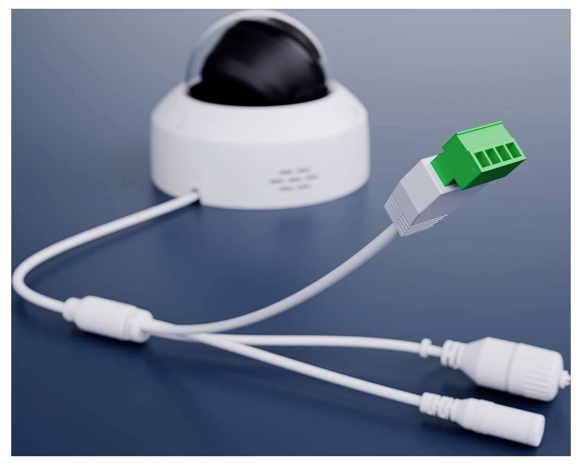 Eine Sicherheitskamera mit einer Kuppelform ist mit mehreren Kabeln, einschließlich eines grünen Klemmblocks, vor einem dunkelblauen Hintergrund verbunden.