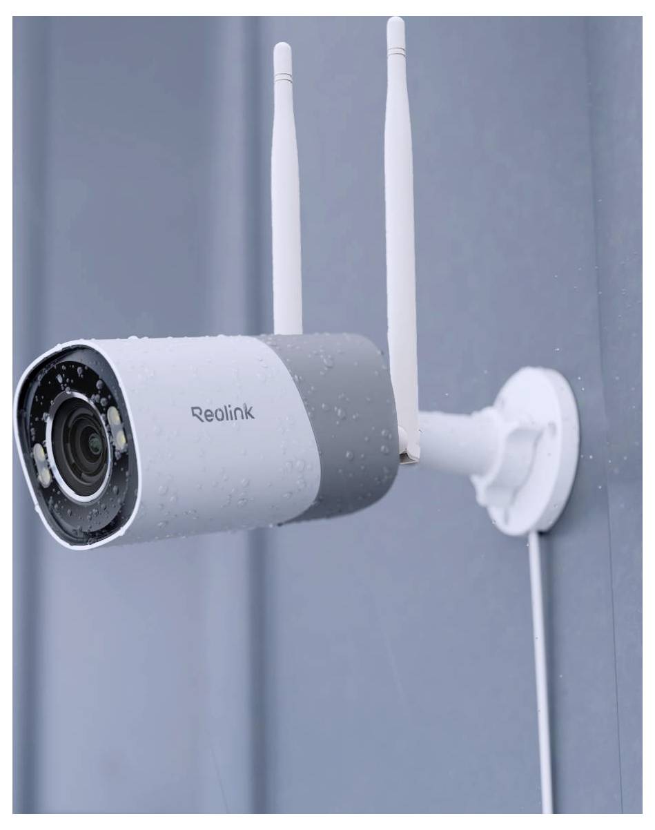 Eine Sicherheitskamera mit Antennen, die an einer Außenwand montiert ist, mit Regentropfen auf ihrer Oberfläche, was den Einsatz bei regnerischem Wetter zeigt.