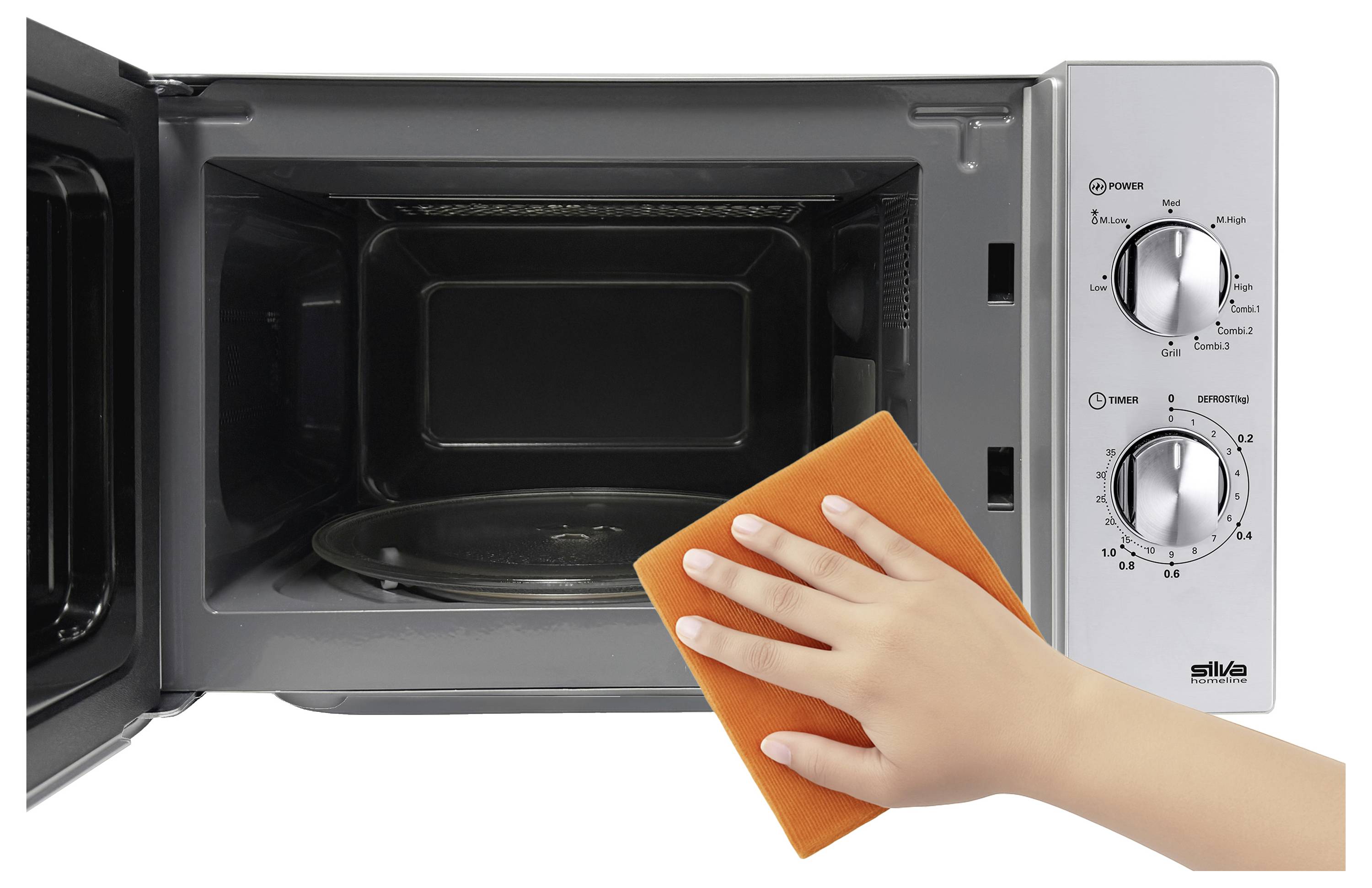 Ein offener Mikrowellenherd mit einer Hand, die einen orangefarbenen Schwamm hält, was auf Reinigung oder Wartung hinweist. Drehknöpfe für Leistung, Timer und Auftaufunktion sind sichtbar.