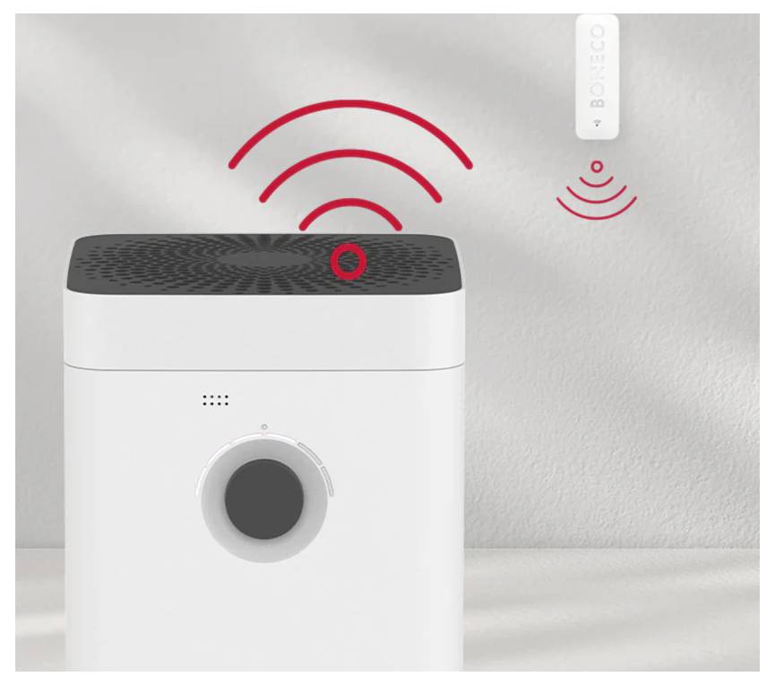 Ein weißer Luftreiniger mit einem schwarzen Deckel zeigt rote drahtlose Signalwellen, die zu einem kleinen, weiß an der Wand montierten Sensor mit der Aufschrift 
