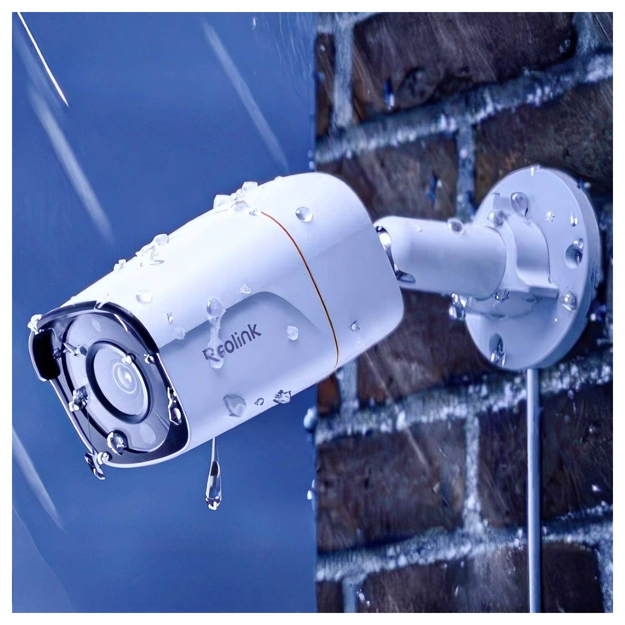 Eine Sicherheitskamera, die an einer Ziegelwand bei Regen montiert ist, mit sichtbaren Wassertropfen auf ihrer Oberfläche.