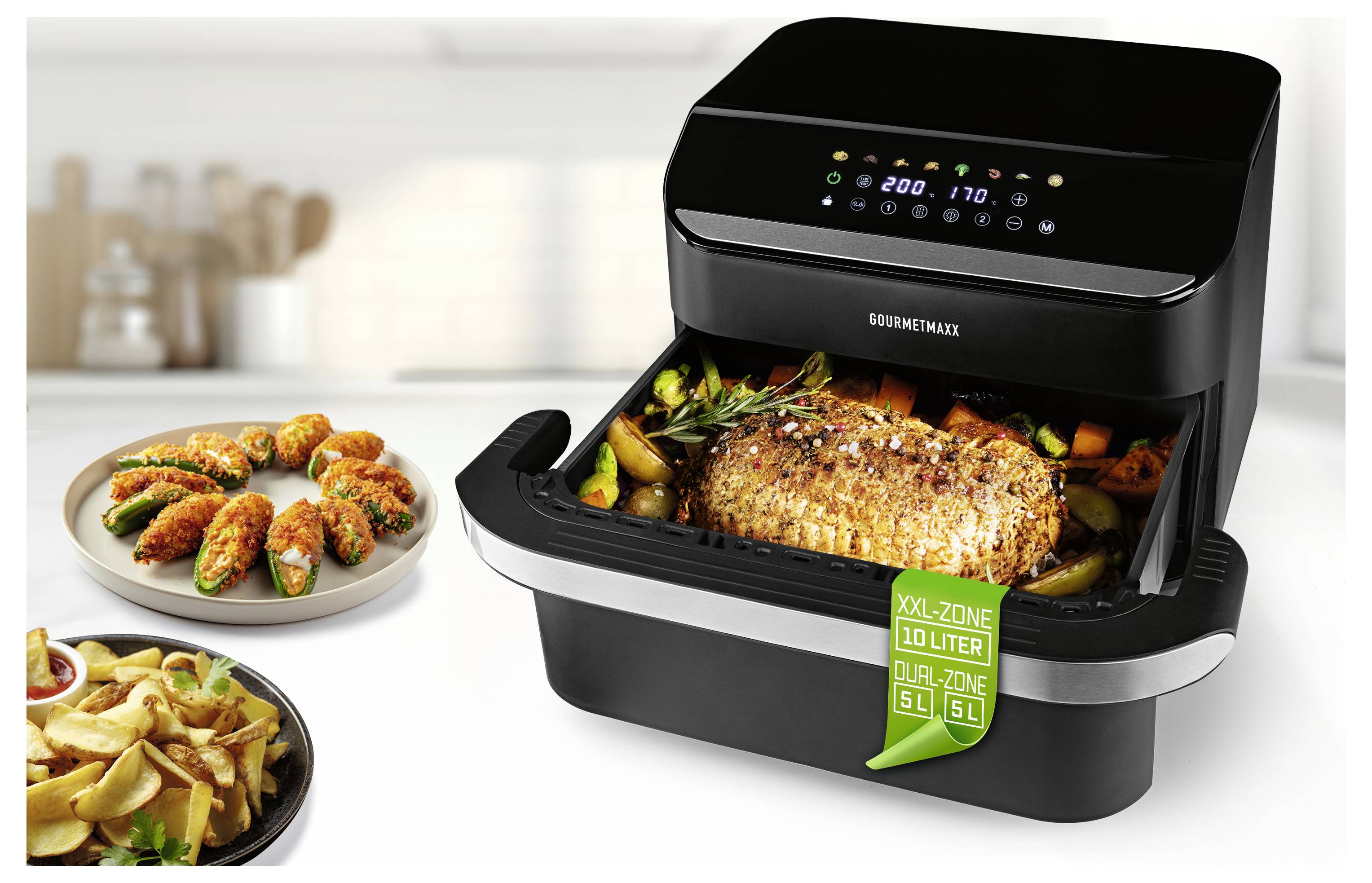 Eine Heißluftfritteuse kocht ein großes Stück gewürztes Fleisch mit Gemüse. In der Nähe sind Teller mit Pommes und gefüllten Jalapeños zu sehen.