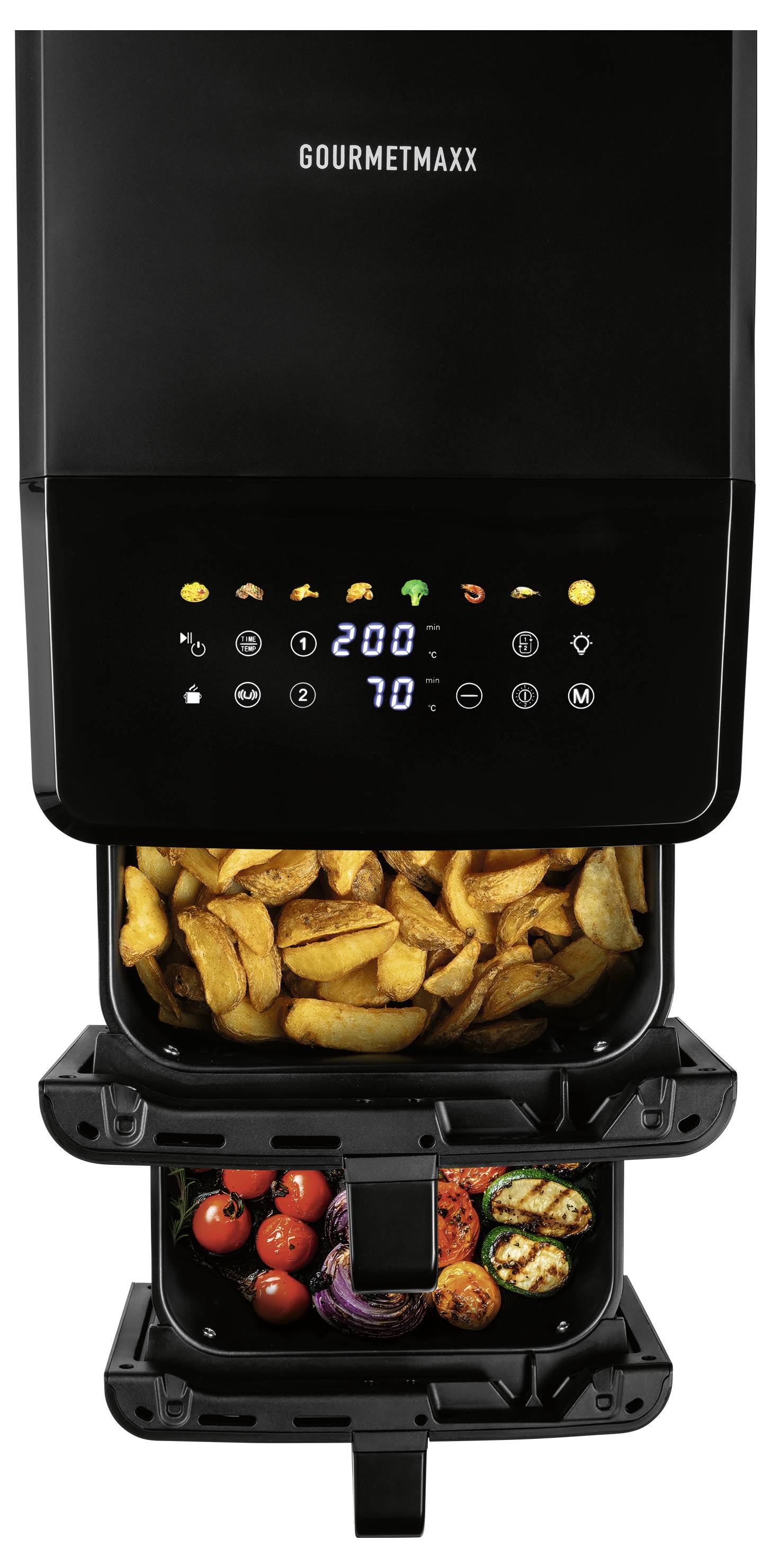 Eine schwarze Heißluftfritteuse mit zwei Kammern und digitaler Steuerung im oberen Bereich, in der in Scheiben geschnittene Kartoffeln, Kirschtomaten, gegrilltes Gemüse und Zwiebeln zubereitet werden.