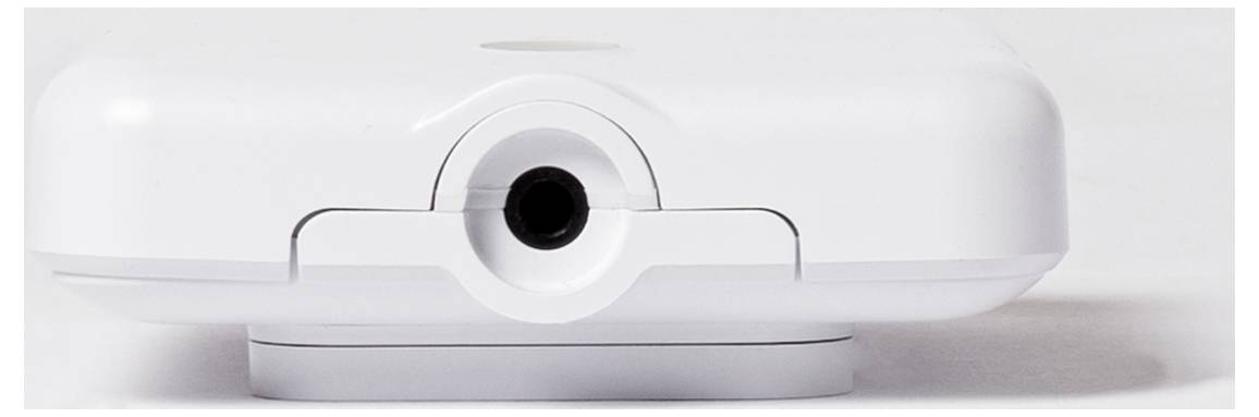 Ein weißes elektronisches Gerät mit einem kreisrunden schwarzen Anschluss auf der Vorderseite, das auf einem weißen Hintergrund platziert ist.