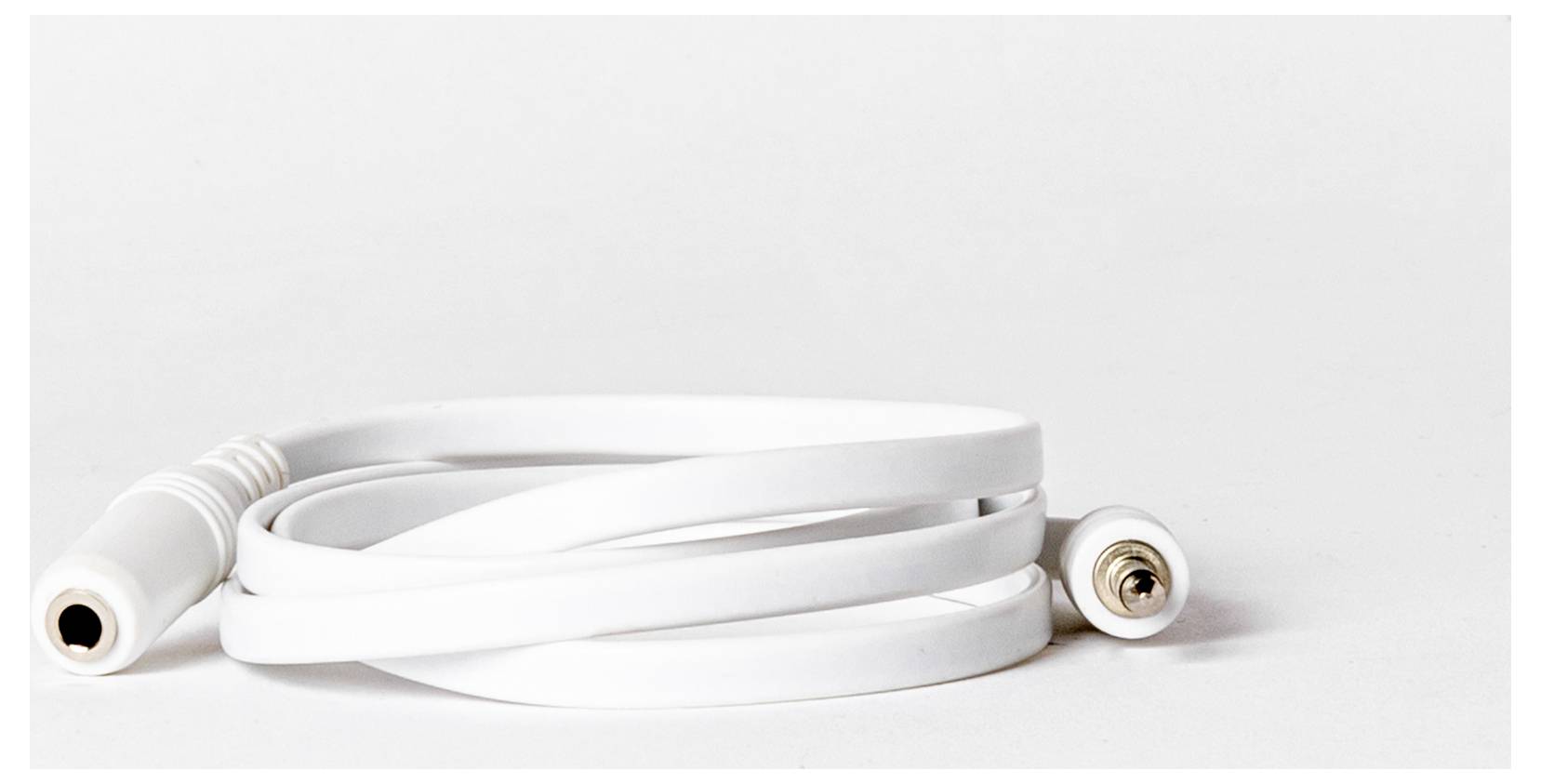 Ein aufgewickeltes weißes Audiokabel mit einem Buchsenanschluss auf der einen Seite und einem Stecker auf der anderen Seite, das auf einer weißen Oberfläche liegt.