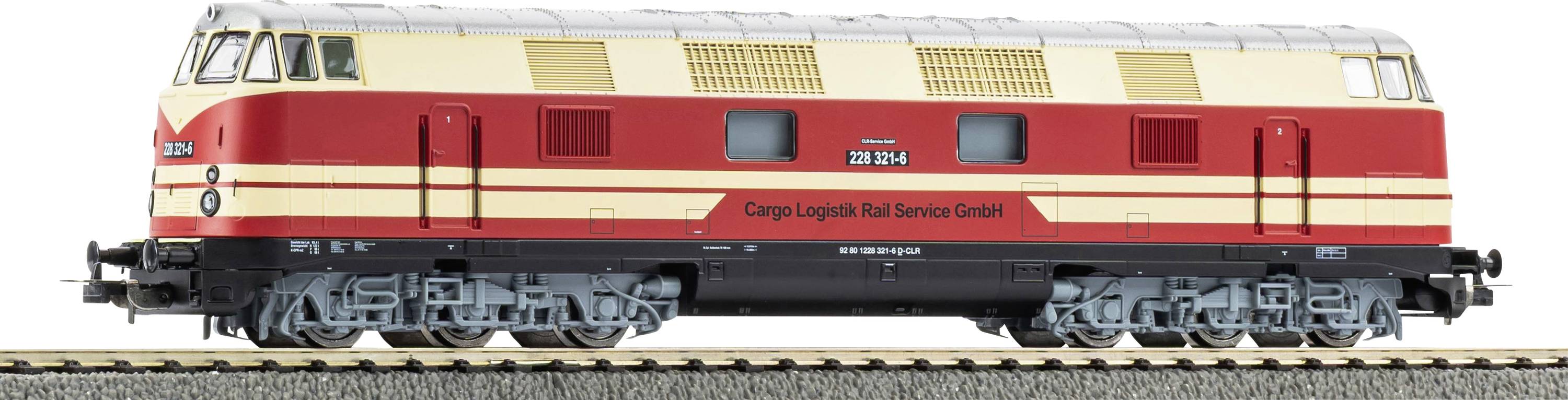 Ein Modelleisenbahn mit 'Cargo Logistik Rail Service GmbH' auf einer rot und beigefarbenen Lokomotive, ausgestellt auf einem Eisenbahngleis.