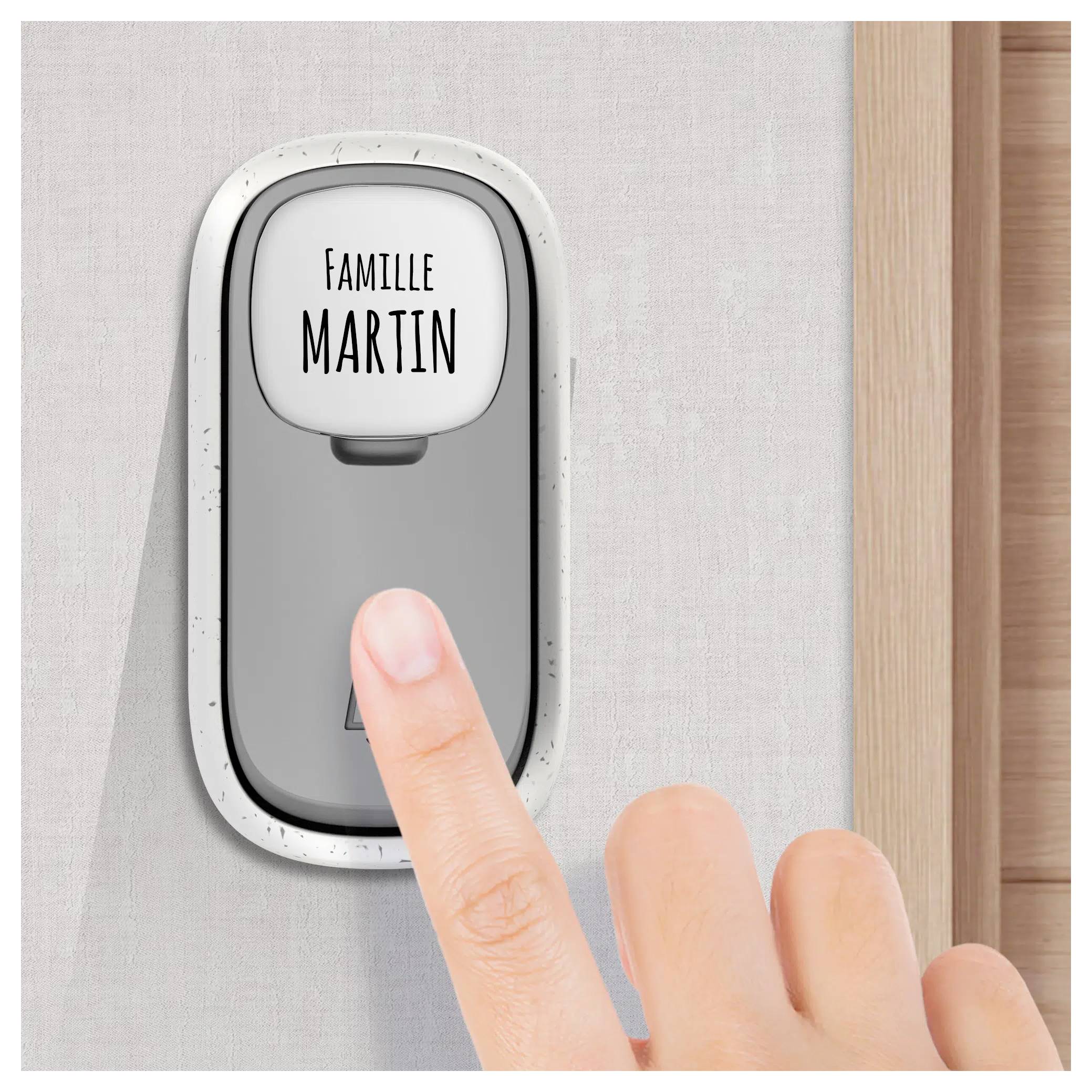 Ein Finger einer Person drückt einen Türklingel mit der Aufschrift 