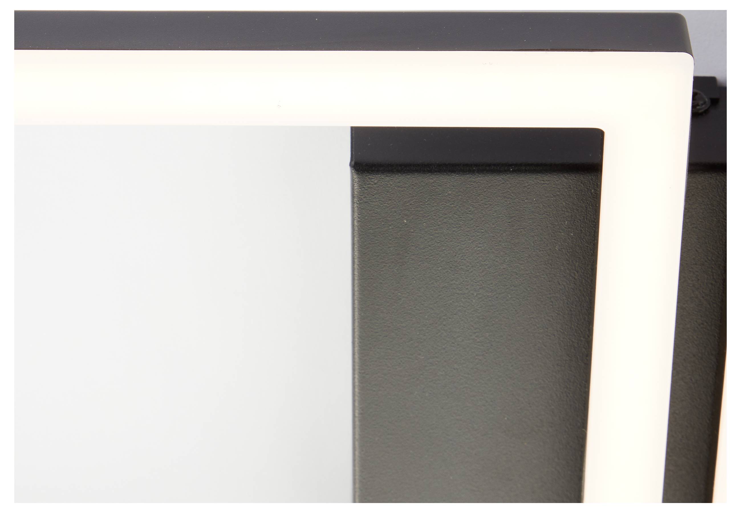 Schräge Ansicht einer modernen, schwarz-weißen geometrischen Leuchte, die teilweise vor einem weißen Hintergrund steht.