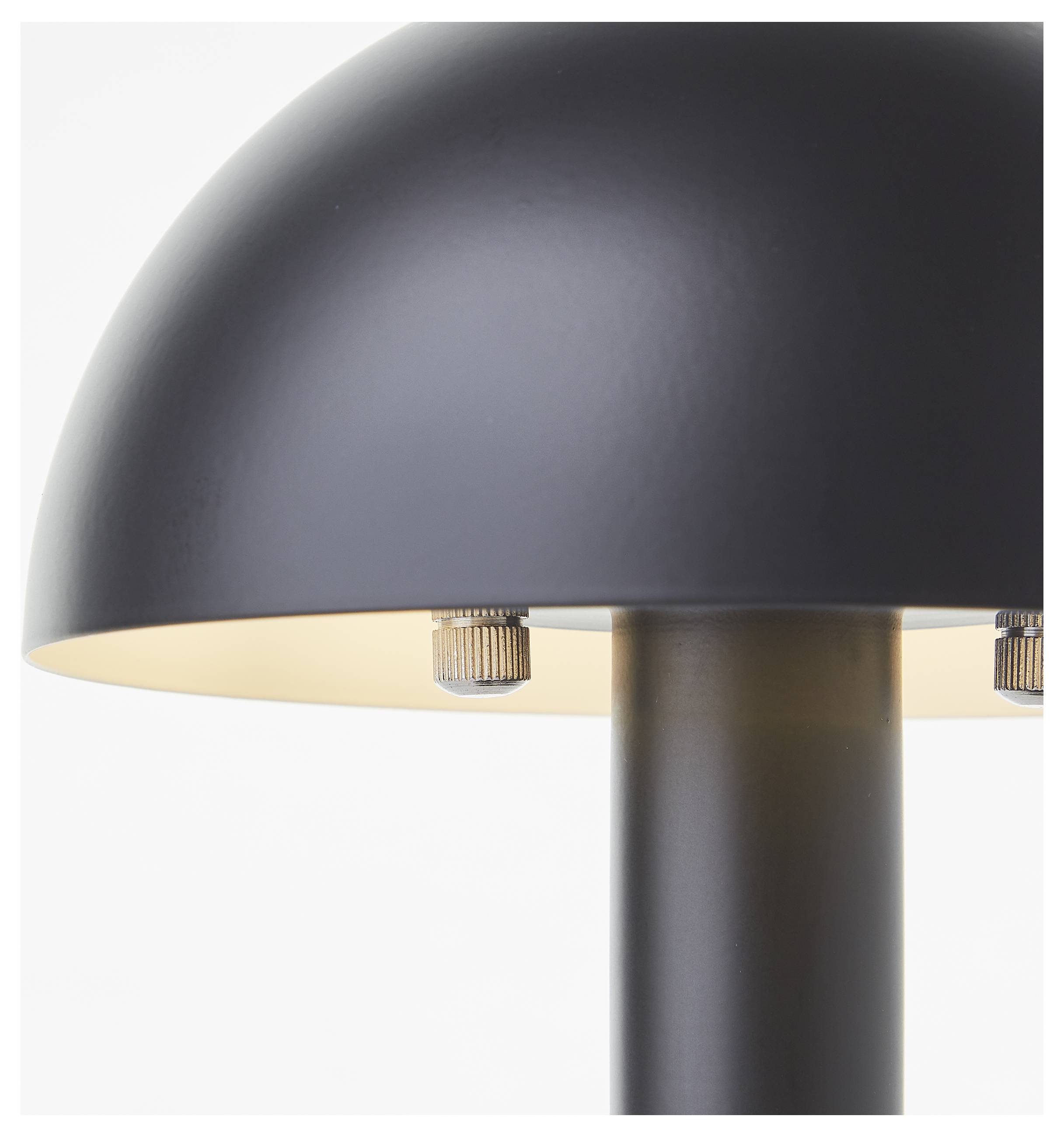 Eine Nahaufnahme einer modernen, schwarzen, kuppelförmigen Tischlampe mit metallischen Befestigungen, die ihr minimalistisches Design hervorhebt.