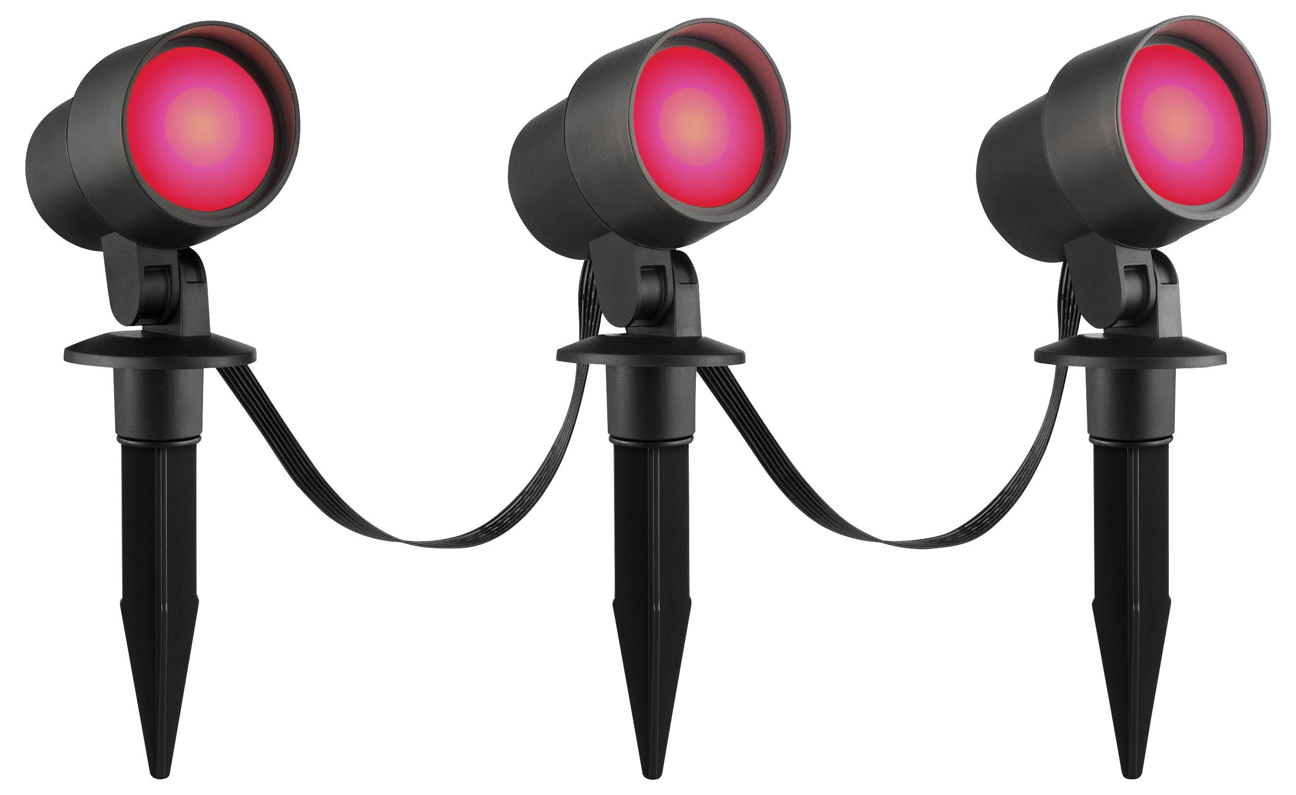 Zwei schwarze Außenscheinwerfer mit glühenden roten Leuchtmitteln sind durch ein Kabel miteinander verbunden. Die Scheinwerfer sind auf spitzen Erdspießen montiert.