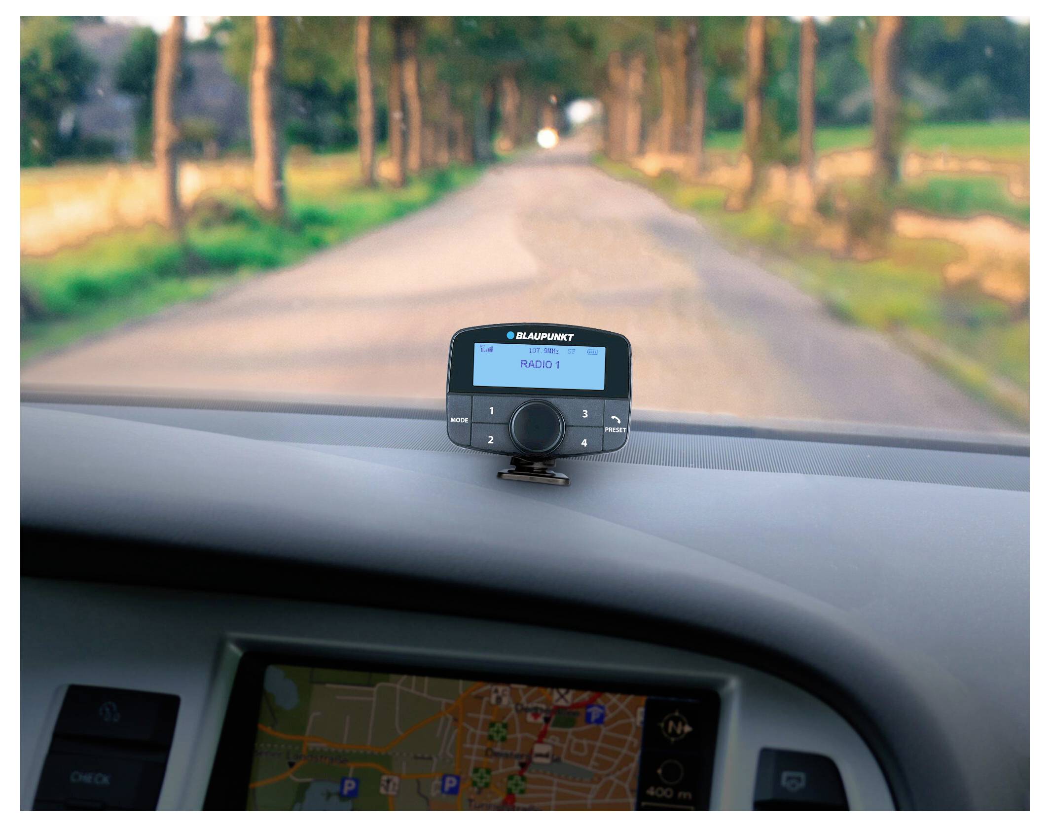 Ein Auto-Armaturenbrett zeigt einen Navigationssystem-Bildschirm mit einer Landstraßenkarte an. Ein Blaupunkt-Radio zeigt 