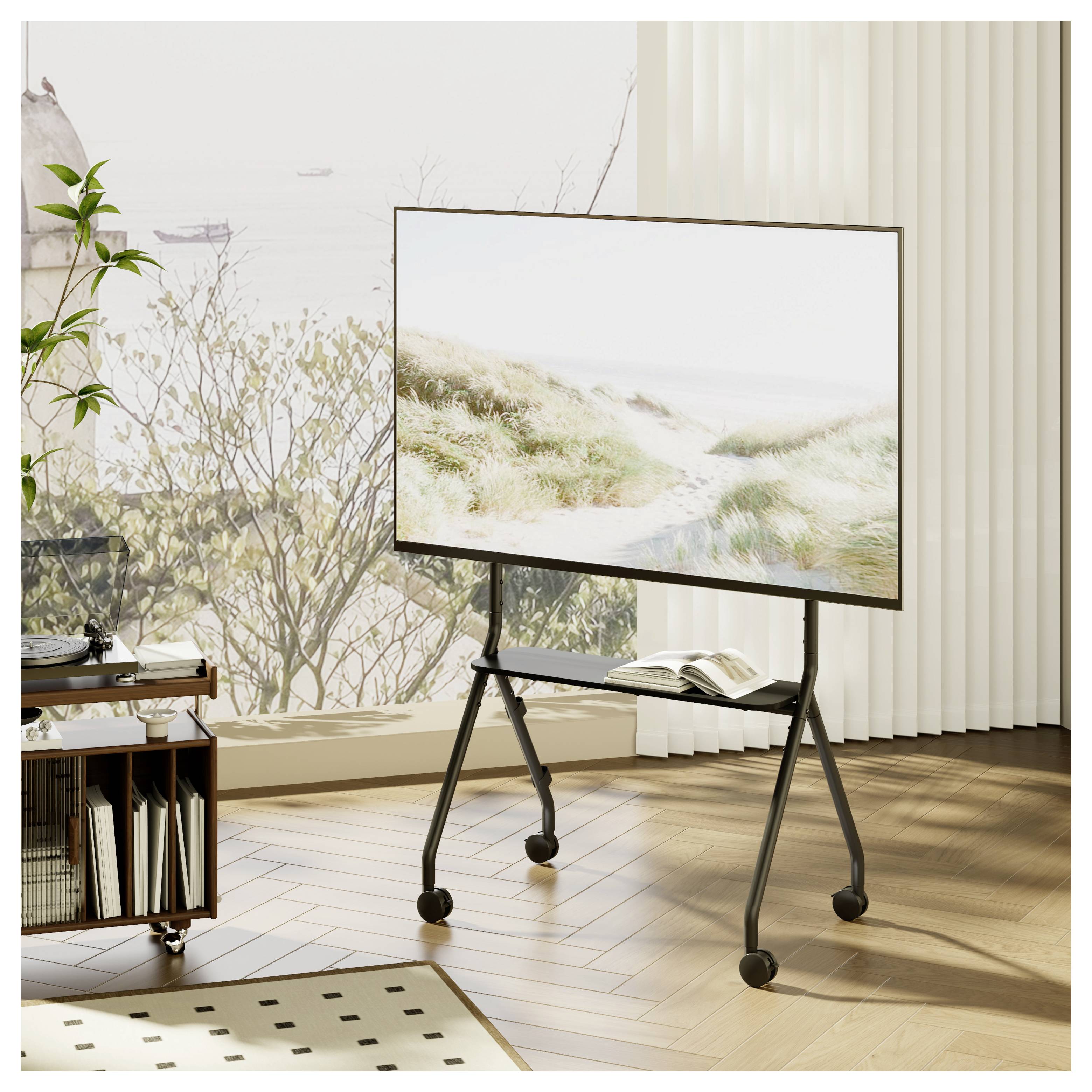 Ein großer Flachbildfernseher auf einem fahrbaren Ständer in einem hellen Raum, der eine helle Strandszene zeigt, mit einem aufgeschlagenen Buch auf seinem Regal.