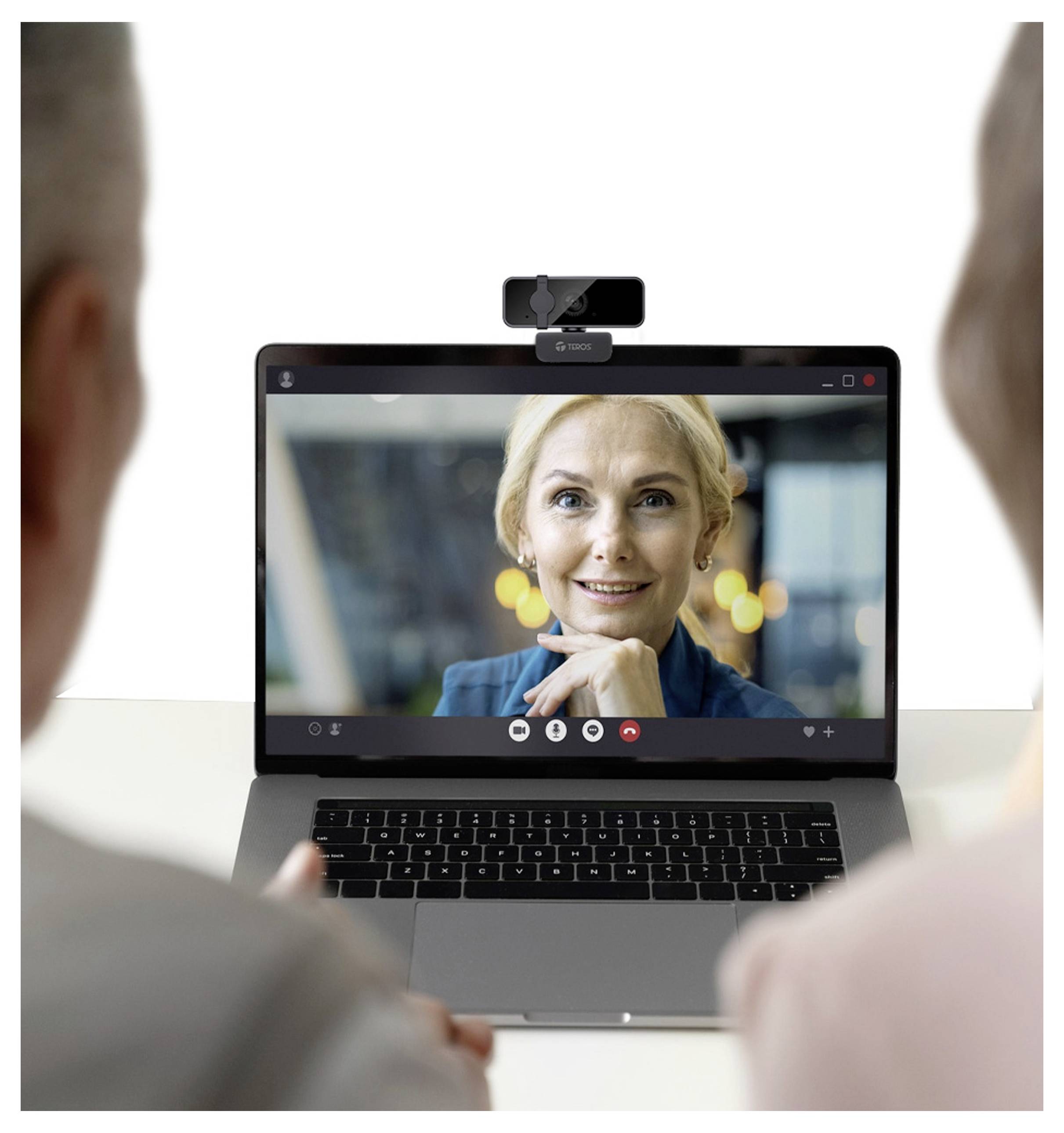 Zwei Personen nehmen an einem Videoanruf auf einem Laptop teil. Eine Frau auf dem Bildschirm spricht, und eine Webcam ist an den Laptop angeschlossen.