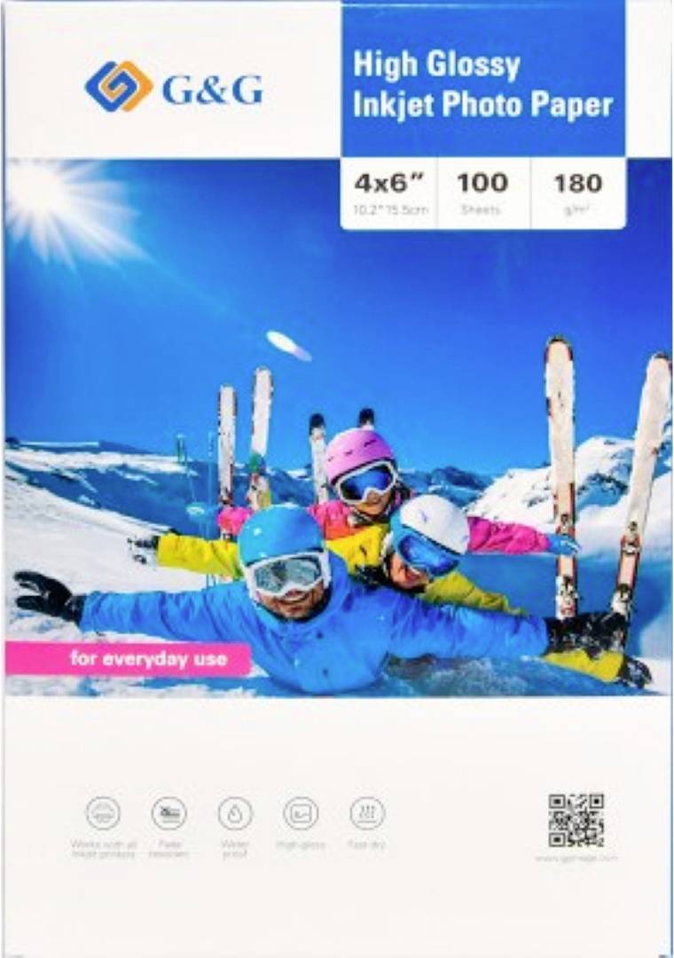 Eine Gruppe von vier Skifahrern, gekleidet in bunte Winterkleidung, posiert fröhlich im Schnee mit Bergen im Hintergrund.