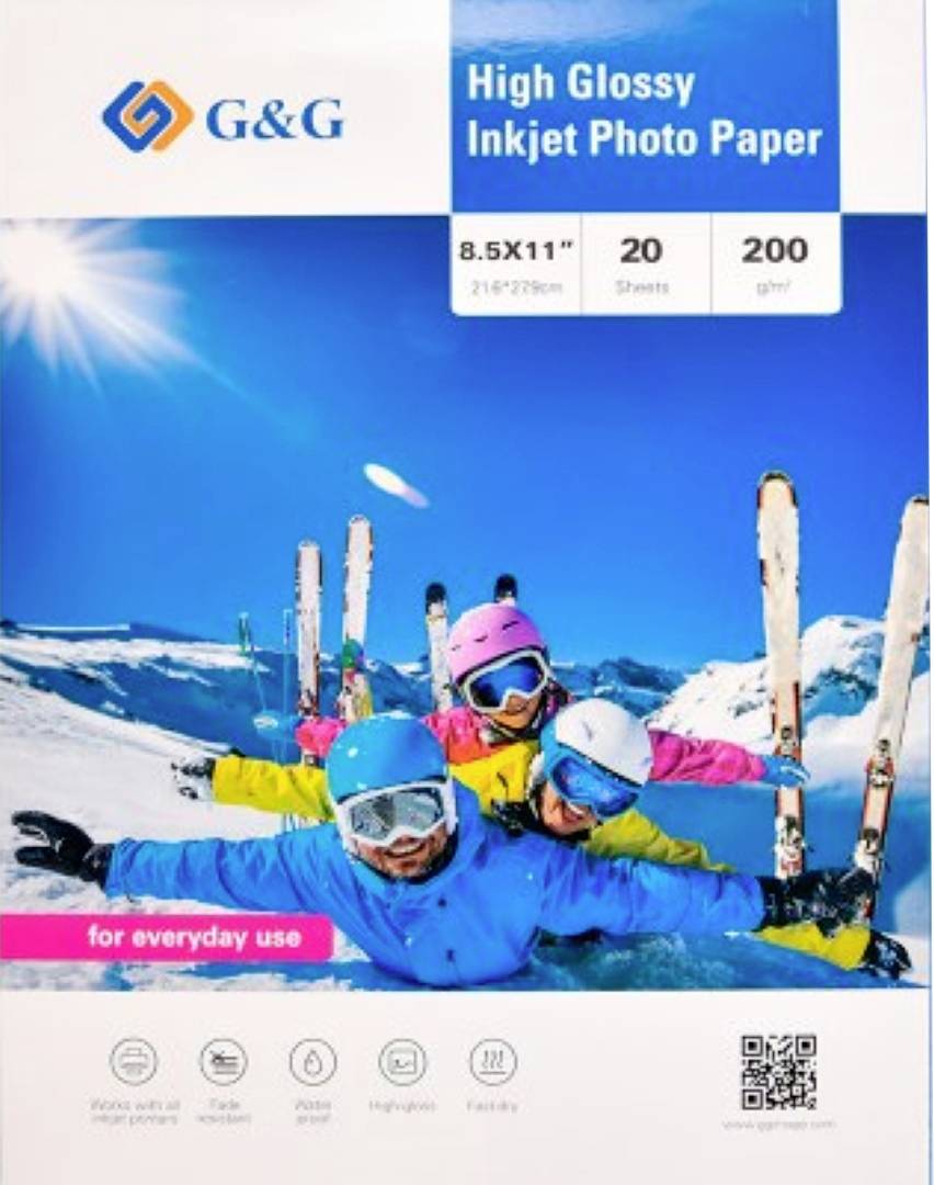 Eine Packung G&G Hochglanz-Fotopapier für Tintenstrahldrucker mit einem Bild von drei lächelnden Skifahrern in bunten Outfits, die auf einem verschneiten Berg posieren.