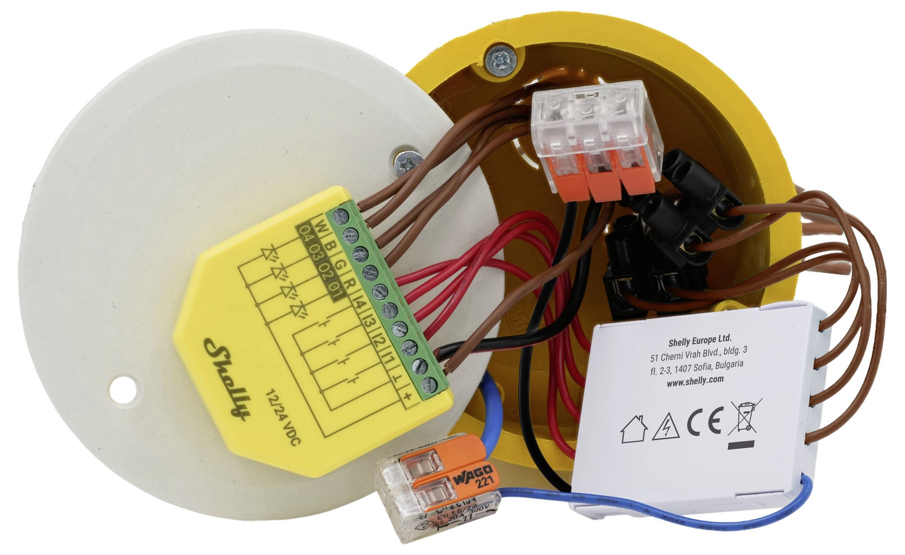 Elektrische Schaltkreise und Komponenten einschließlich eines Shelly-Geräts, Steckverbindungsblöcke und Verdrahtung innerhalb eines gelben kreisförmigen Gehäuses.