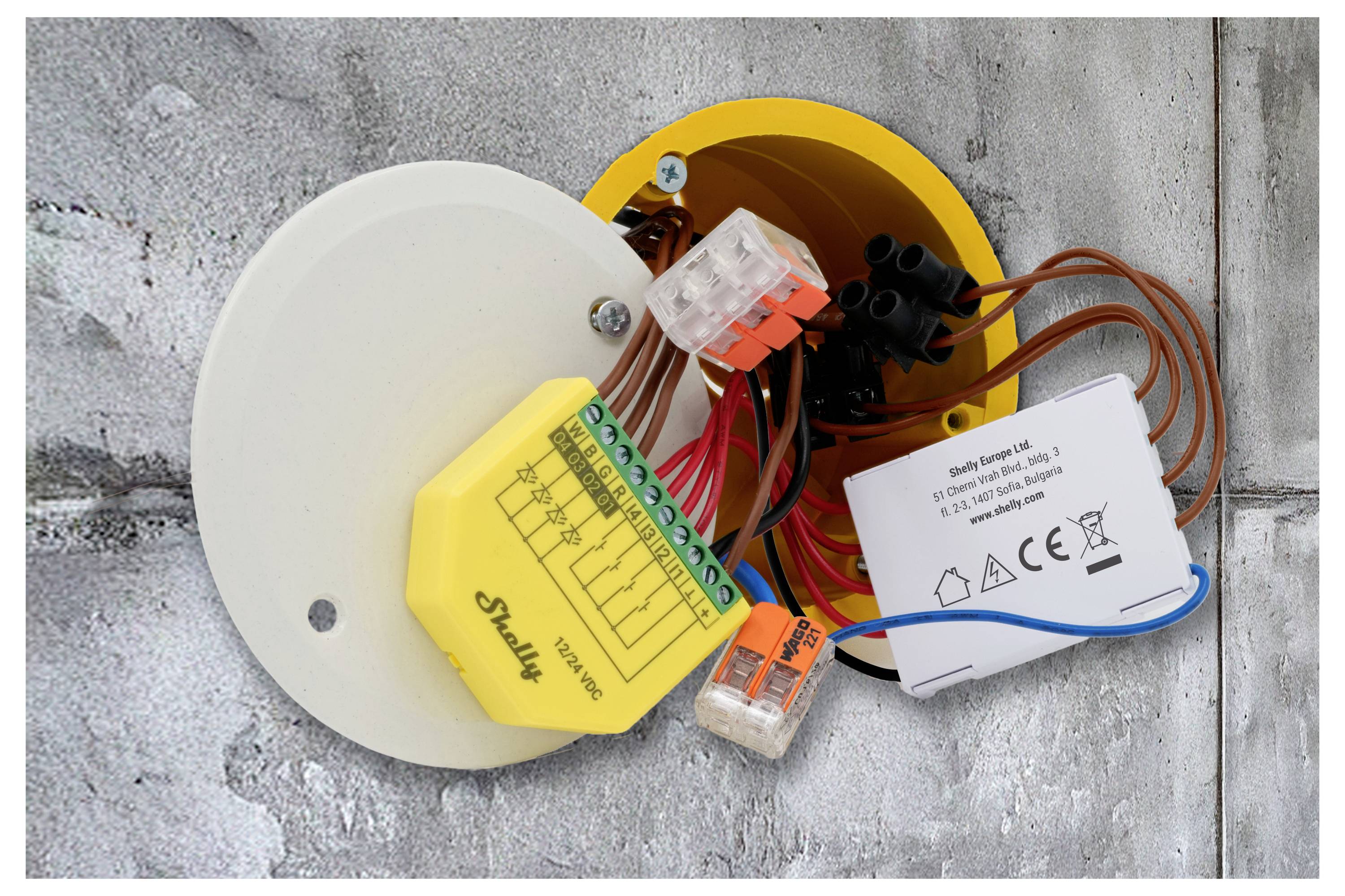 Eine weiße Fernbedienung mit schwarzen Tasten, einschließlich eines zentralen Drehreglers, zwei kleiner Pfeiltasten und drei LED-Anzeigelichtern.