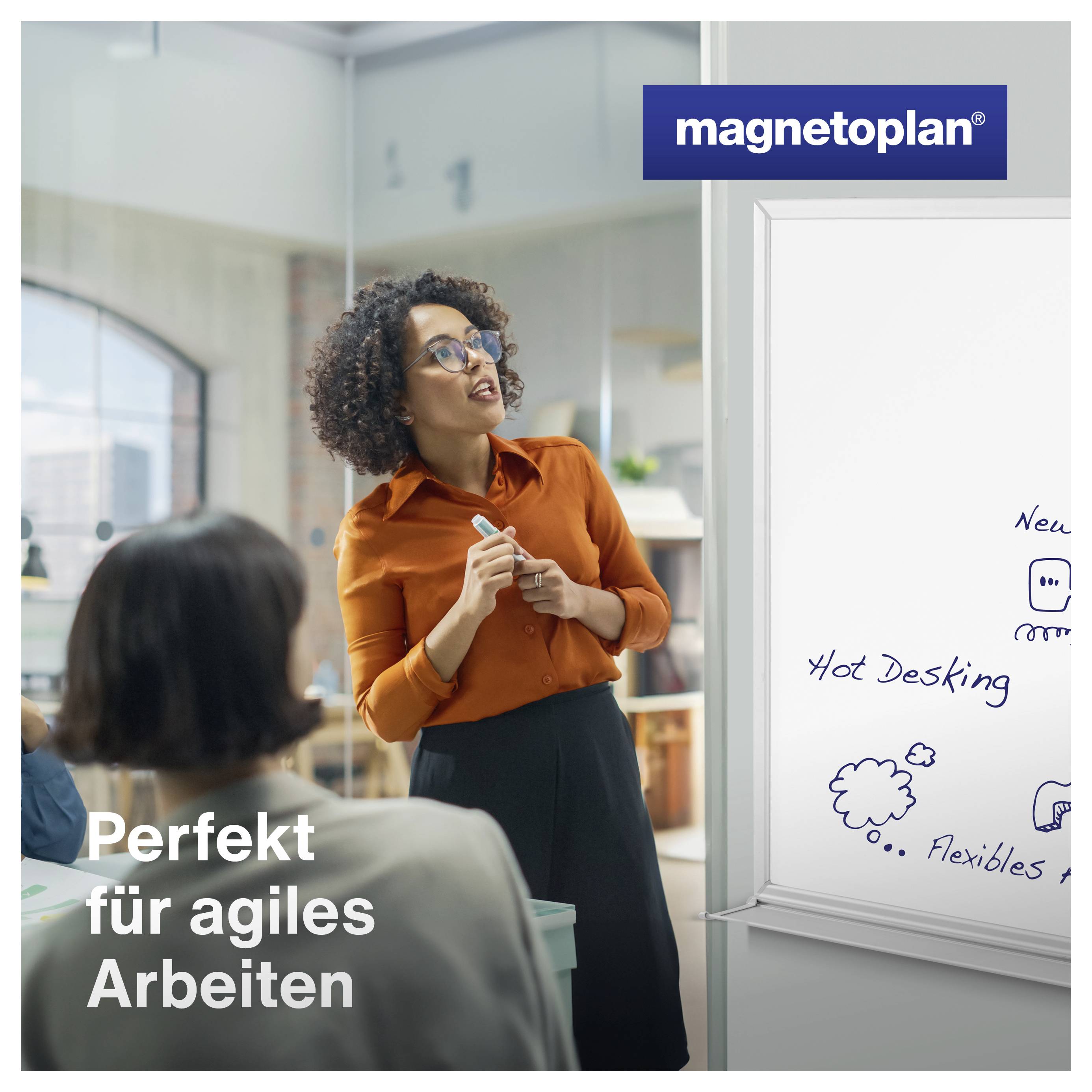 Eine Person steht vor einem Whiteboard und erklärt etwas in einem modernen Büro. Text auf dem Whiteboard: 'Hot Desking'; Slogan: 'Perfekt für agiles Arbeiten'.