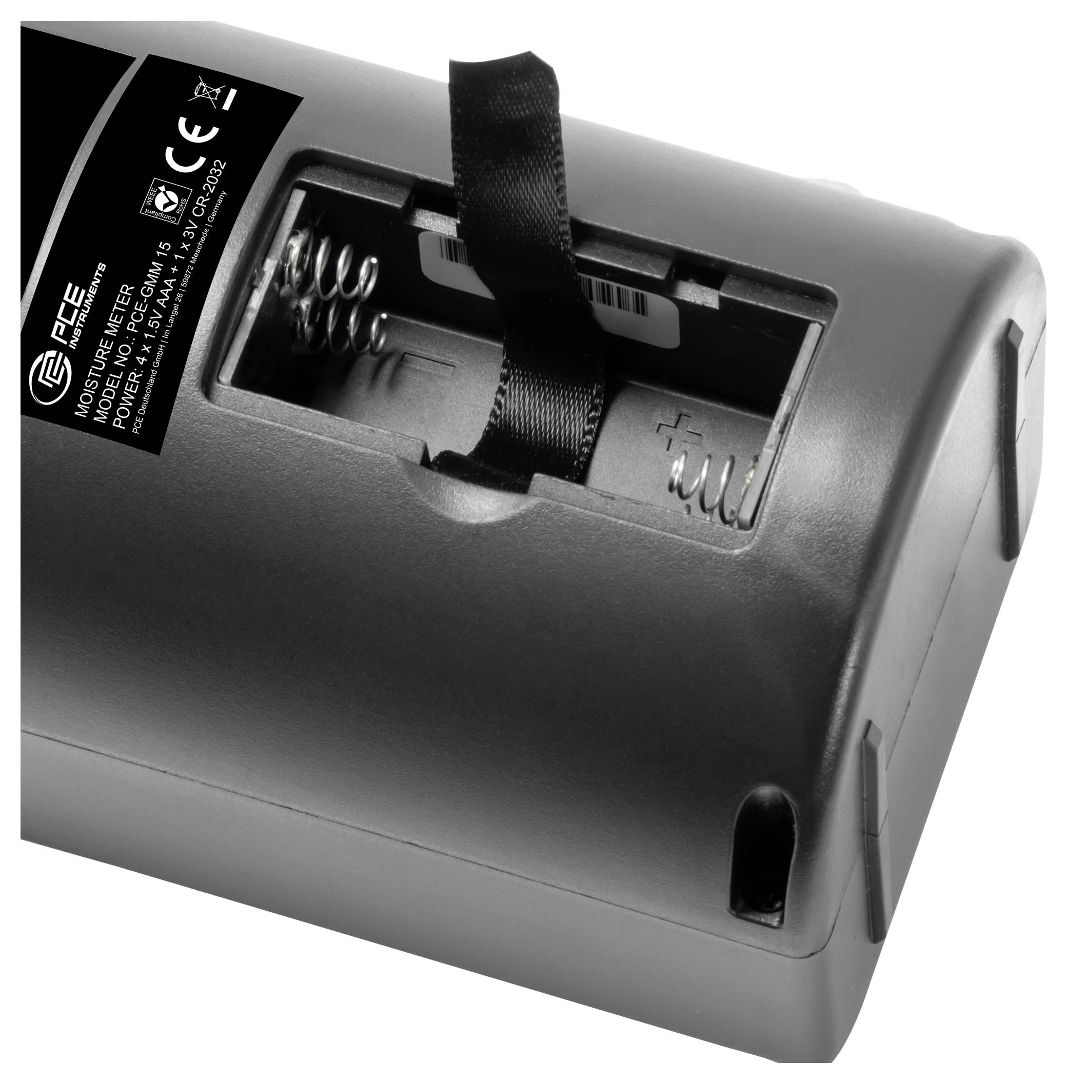 Nahaufnahme eines Batteriefachs an einem schwarzen Gerät, das Federkontakte und eine Lasche zum Einsetzen oder Entfernen von Batterien zeigt.