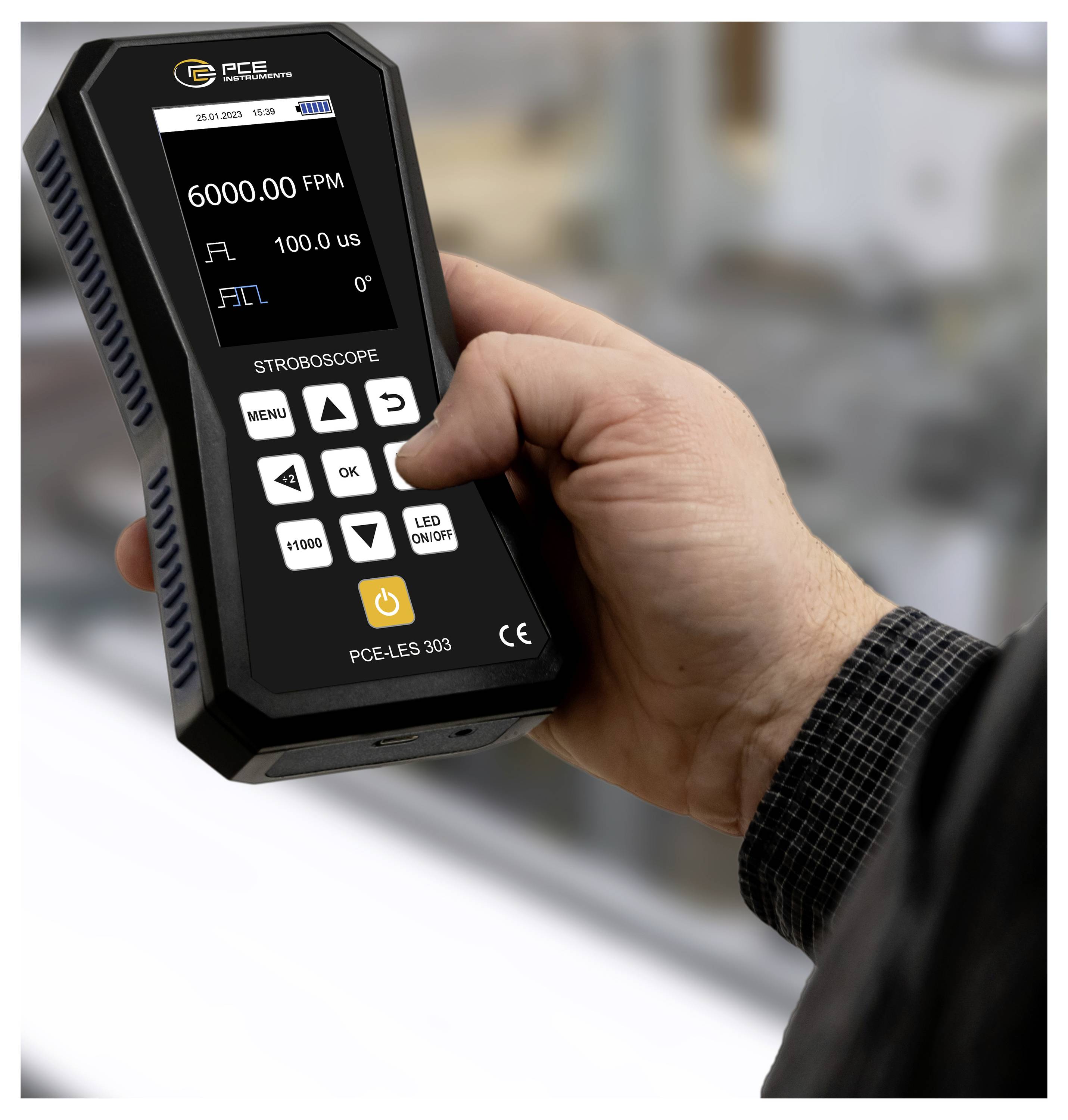 Hand, die ein digitales Stroboskopgerät hält, dessen Display Messwerte von 6000.00 FPM und 100.0 µs anzeigt.