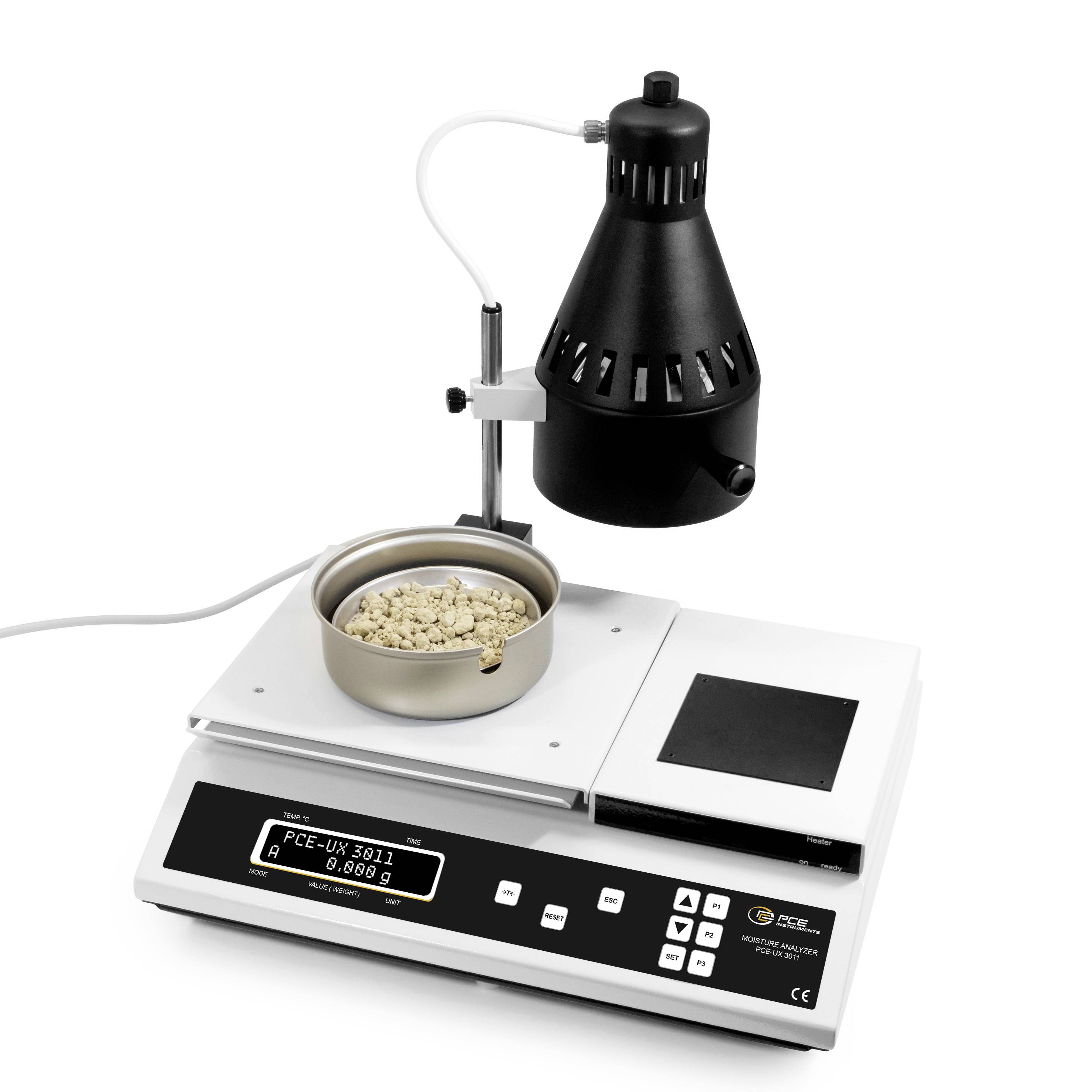 Laboraufbau zur Samenkeimung mit einer beheizten Lampe über einer kleinen Schale mit Samen auf einer digitalen Waage oder einem Analysegerät.