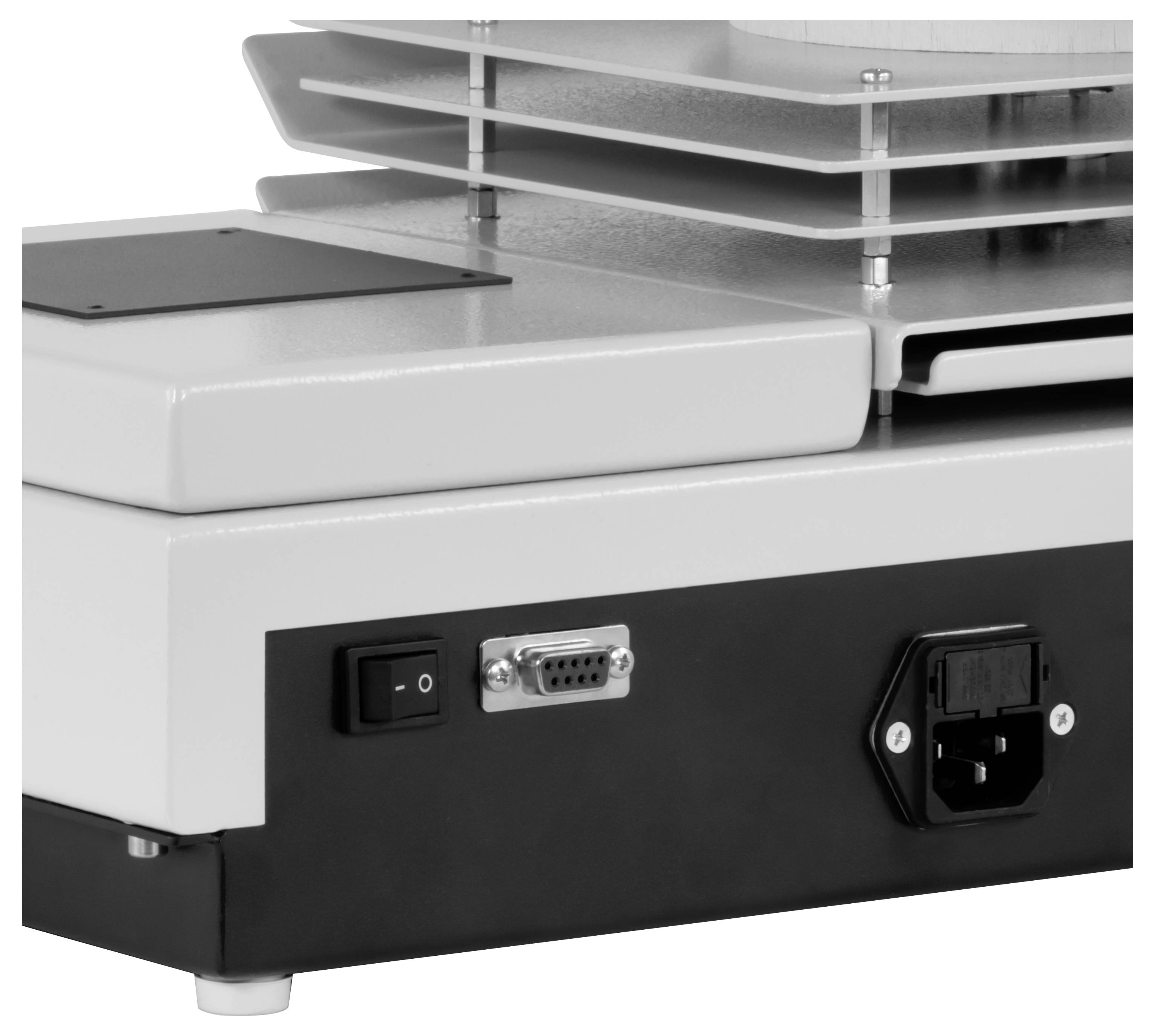 Nahaufnahme der Rückseite eines elektronischen Geräts, auf der ein Netzschalter, eine serielle Schnittstelle und eine Stromversorgungsbuchse unter belüfteten Kühlrippen sichtbar sind.
