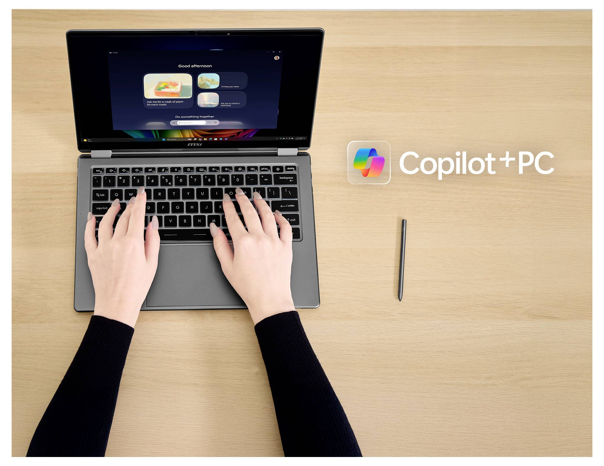 Eine Person tippt auf einem Laptop, neben dem 
