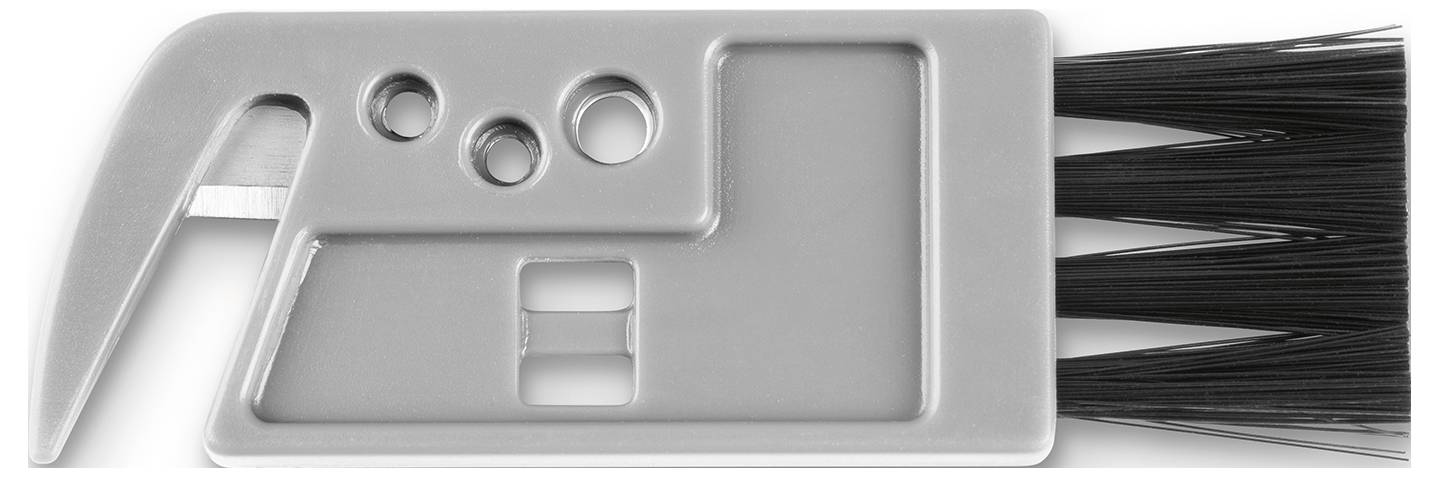 Ein graues Multitool mit einem Metallhaken, Löchern für Funktionen und Bürsten zur Reinigung, wahrscheinlich für die Wartung von Computertastaturen konzipiert.