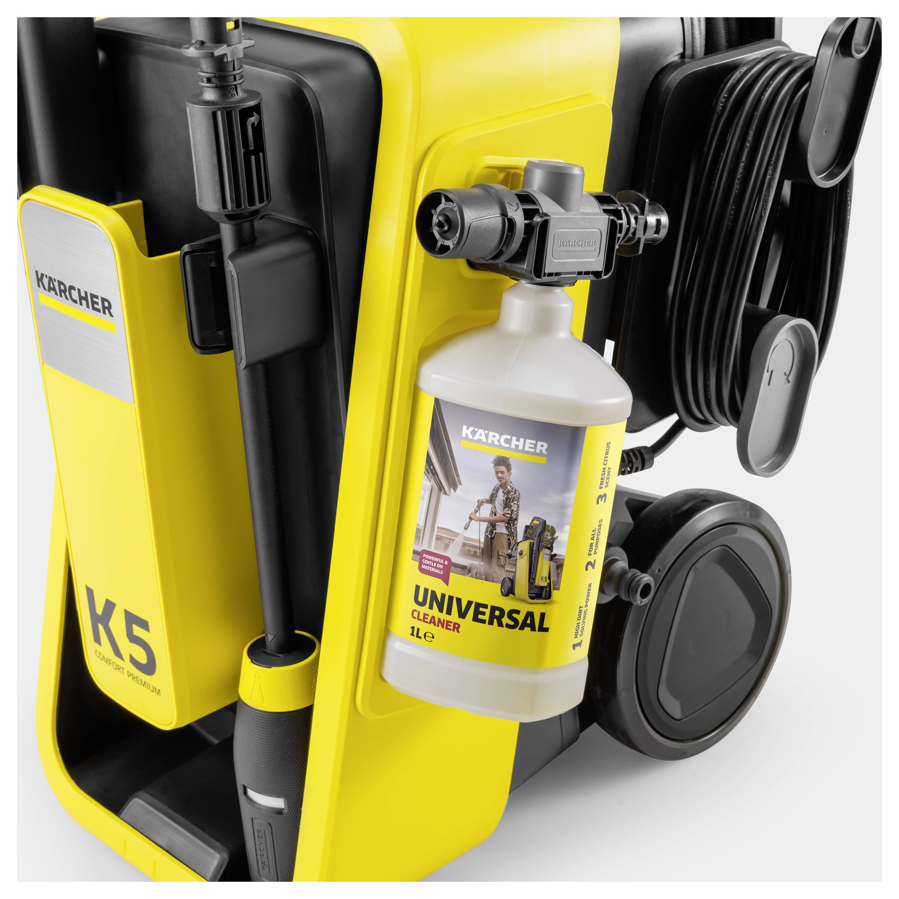 Gelber Kärcher K5 Hochdruckreiniger mit angebrachter Universal-Reiniger-Flasche, einer Schlauchtrommel und einem Düsenhalter.
