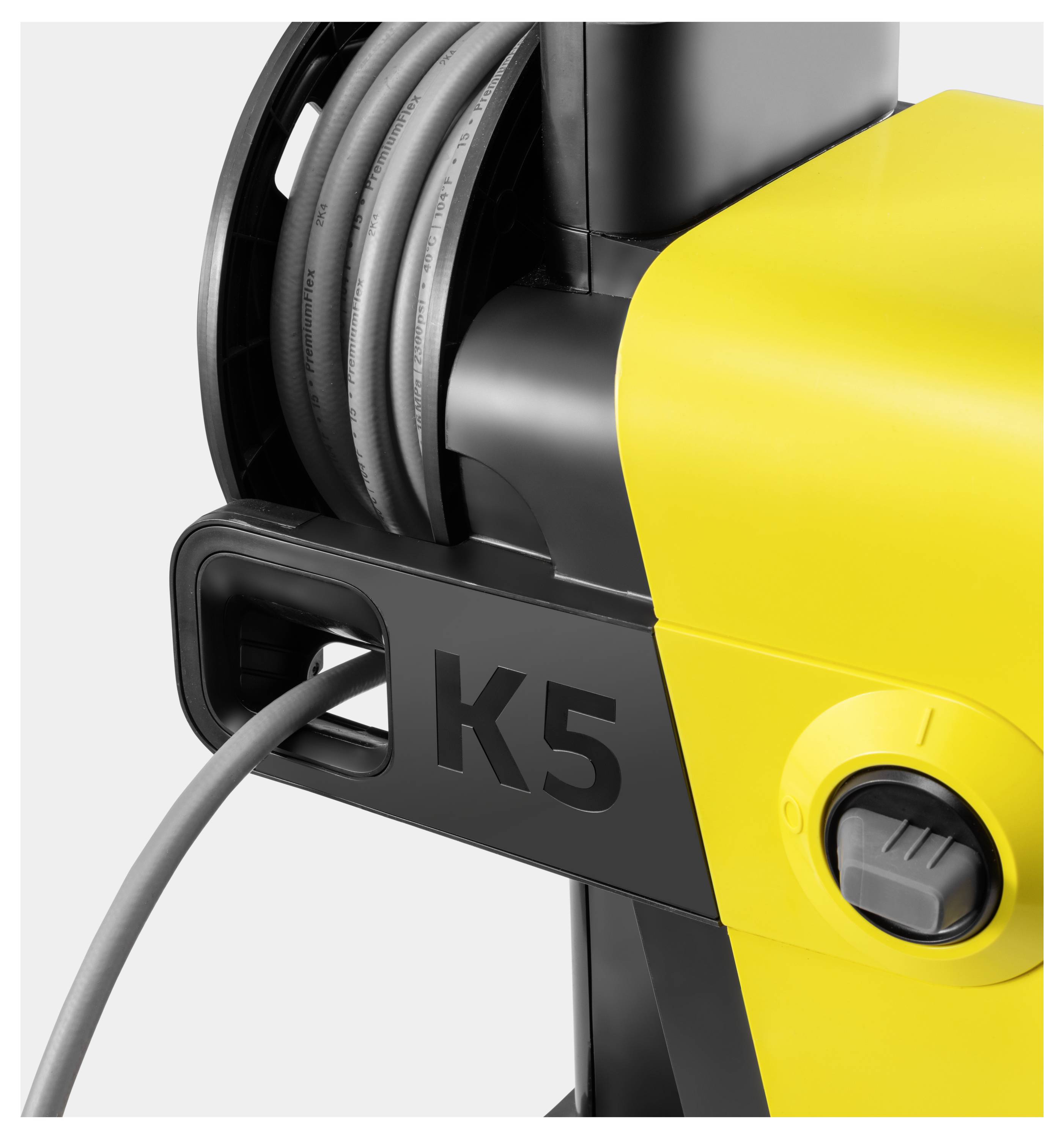 Ein gelb-schwarzer Hochdruckreiniger mit 'K5' auf der Seite und einem aufgerollten Schlauch oben.