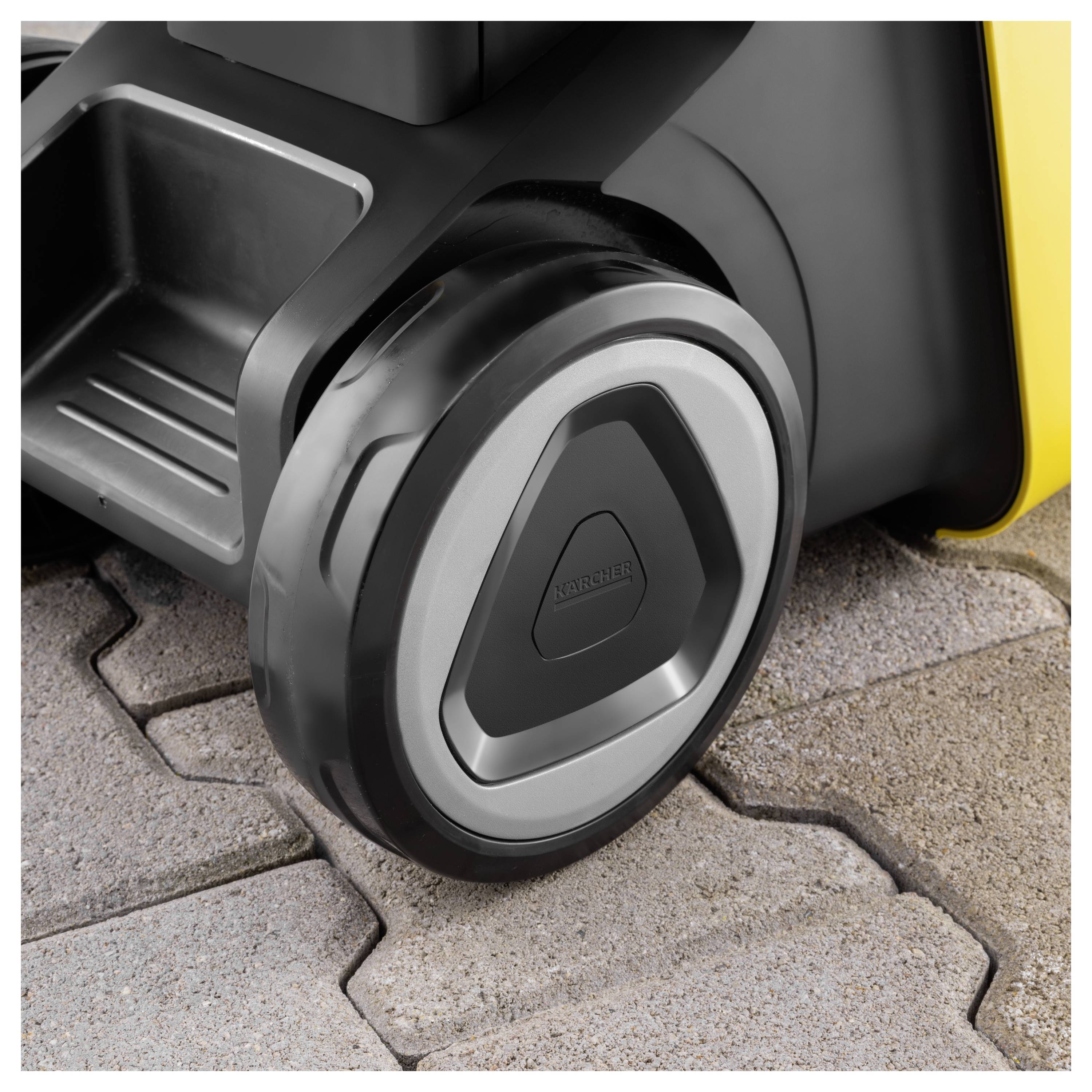 Eine Nahaufnahme eines Kärcher-Rades auf Kopfsteinpflaster, die das Raddesign und die Texturdetails der Oberfläche, auf der es sich bewegt, zeigt.
