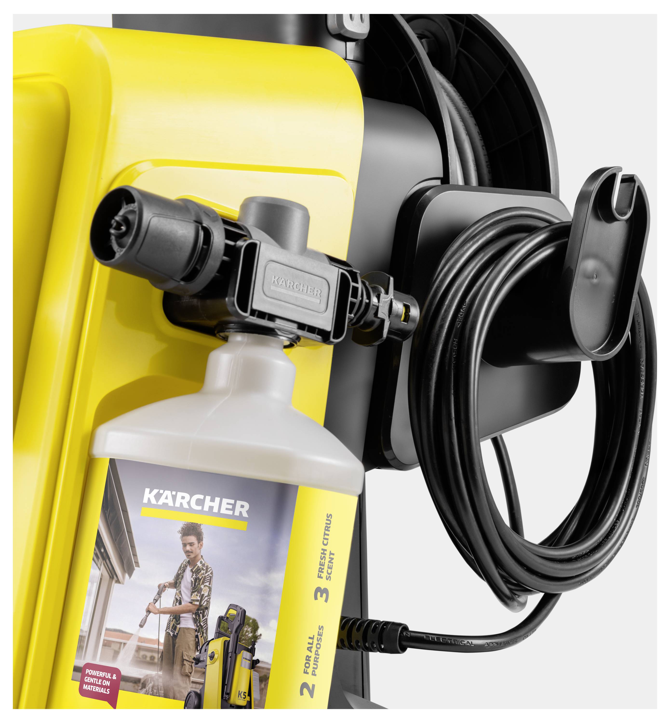 Ein Hochdruckreiniger mit gelbem Rahmen, Waschmittelflasche und aufgewickeltem schwarzem Schlauch, der an diesem befestigt ist, zeigt effiziente Hausreinigung.