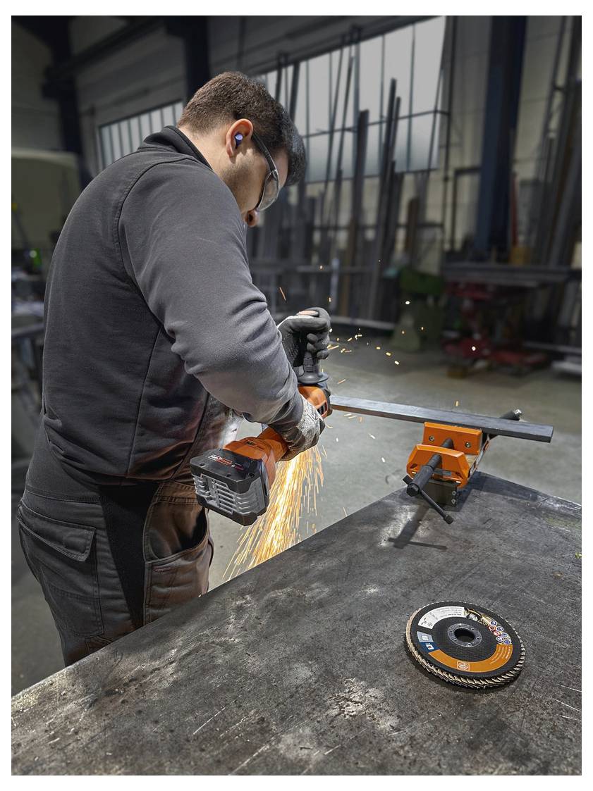 „Mann, der einen tragbaren Winkelschleifen an Metall bedient und dabei Funken erzeugt, in einer Industriewerkstatt. Es wird Schutzausrüstung, einschließlich Gehörschutz, verwendet.