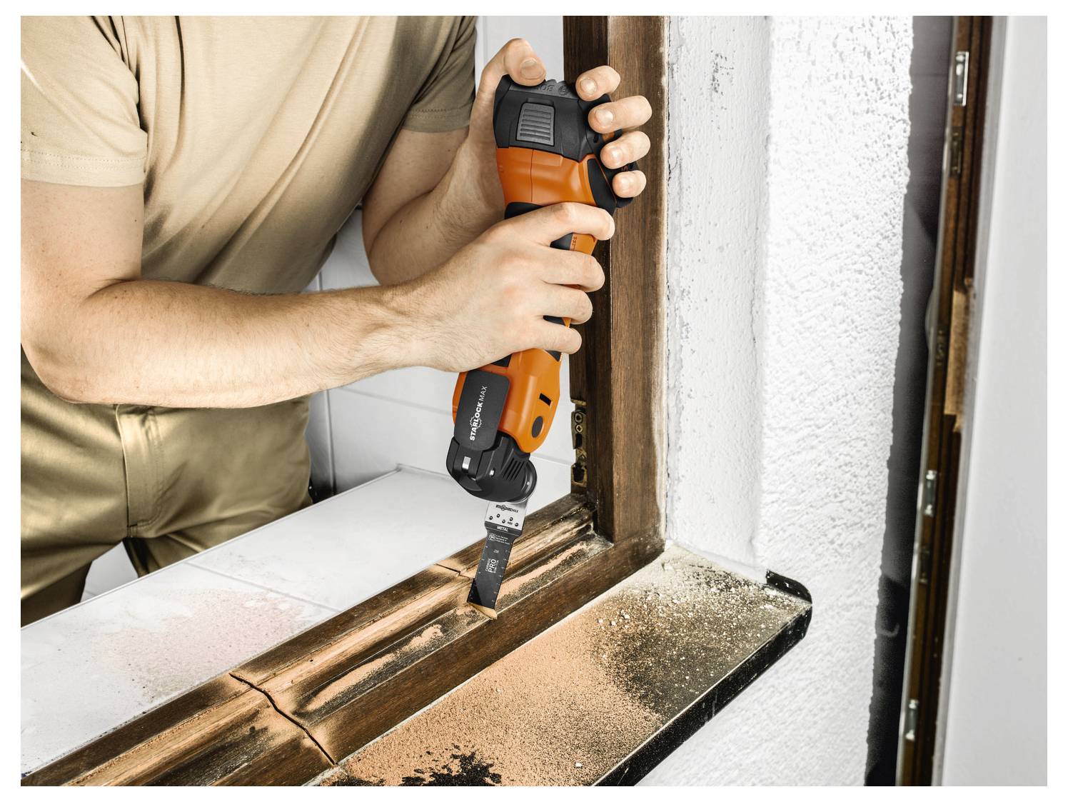 Eine Person benutzt ein orangefarbenes Elektrowerkzeug, um einen hölzernen Fensterrahmen zu schleifen. Staub ist auf der Oberfläche sichtbar.