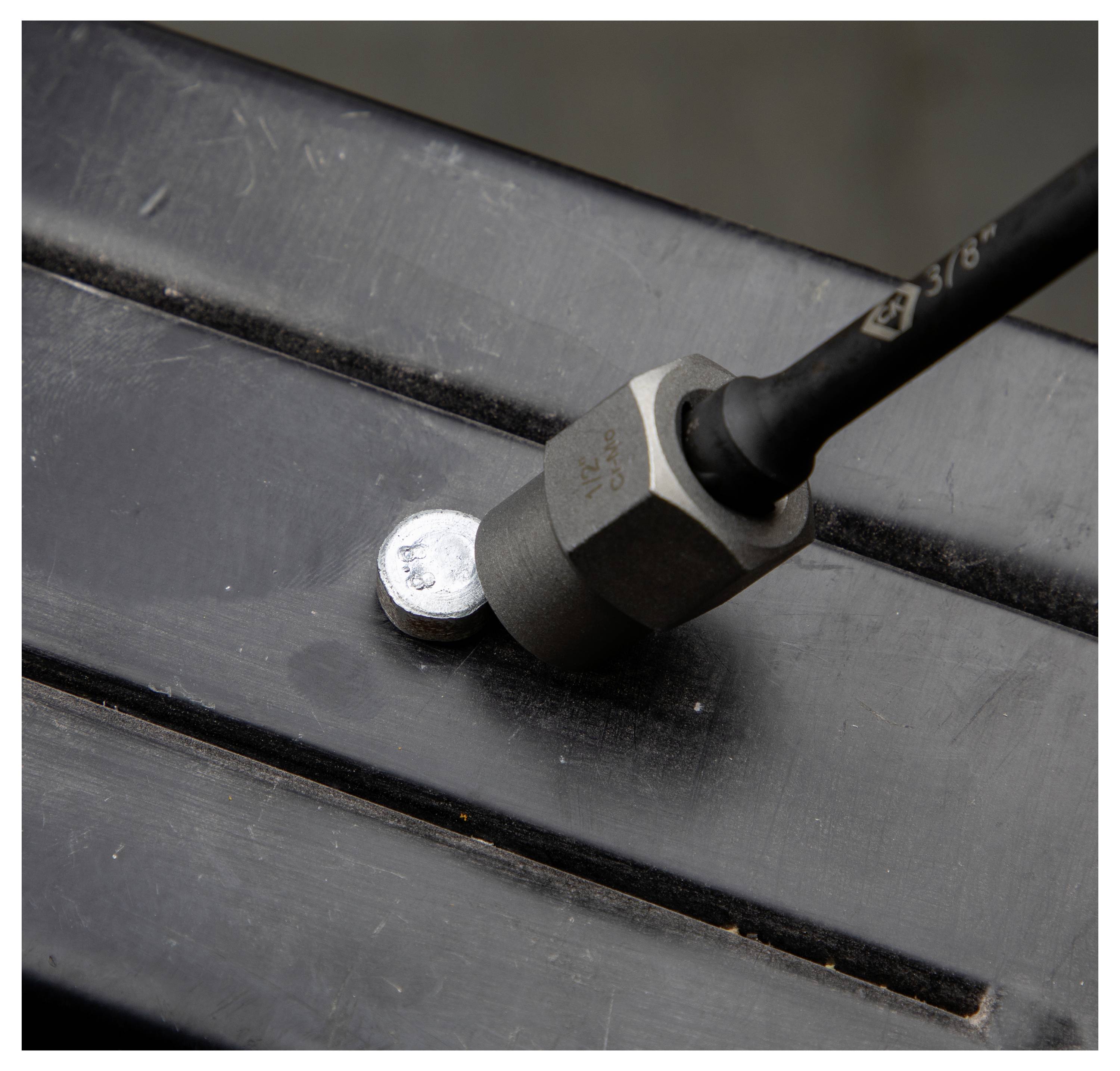 Ein Magnetfühler, der eine Metalloberfläche aus kurzer Entfernung erfasst, dargestellt durch einen zylindrischen Magneten, der an der Oberfläche befestigt ist.