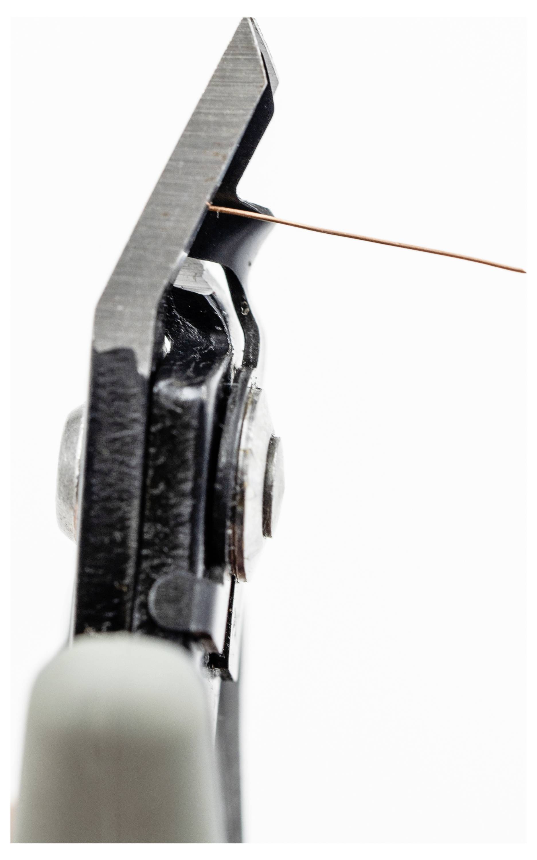 Nahaufnahme eines schwarzen Drahtschneiders, der einen dünnen Kupferdraht vor einem weißen Hintergrund durchtrennt.