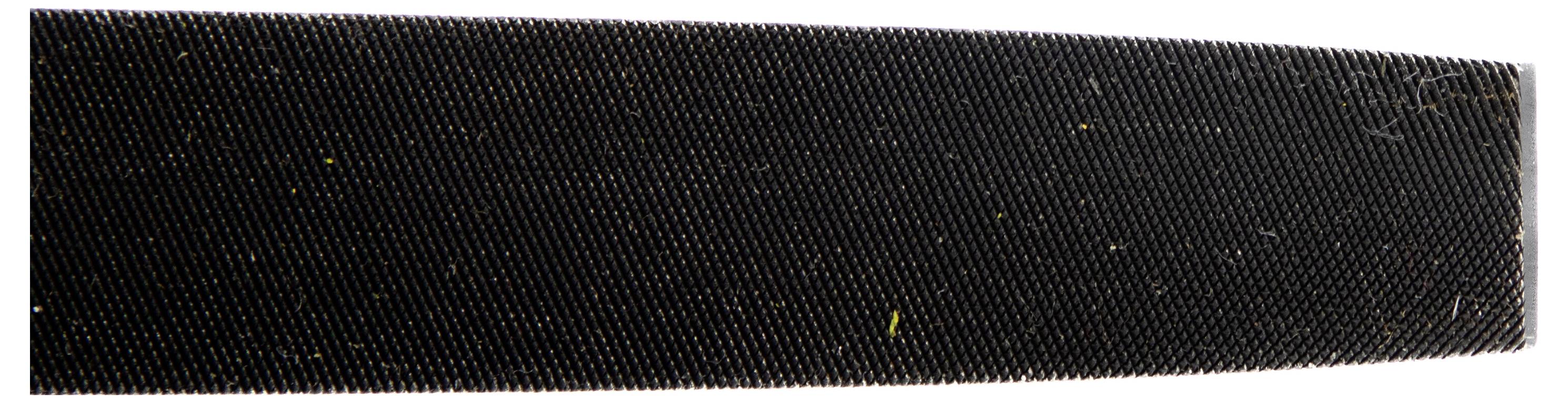 Nahaufnahme einer rauen, strukturierten Oberfläche, die einer Feile oder einem Schleifmittel ähnelt, mit feinen Rillen und Partikeln auf dunklem Hintergrund.