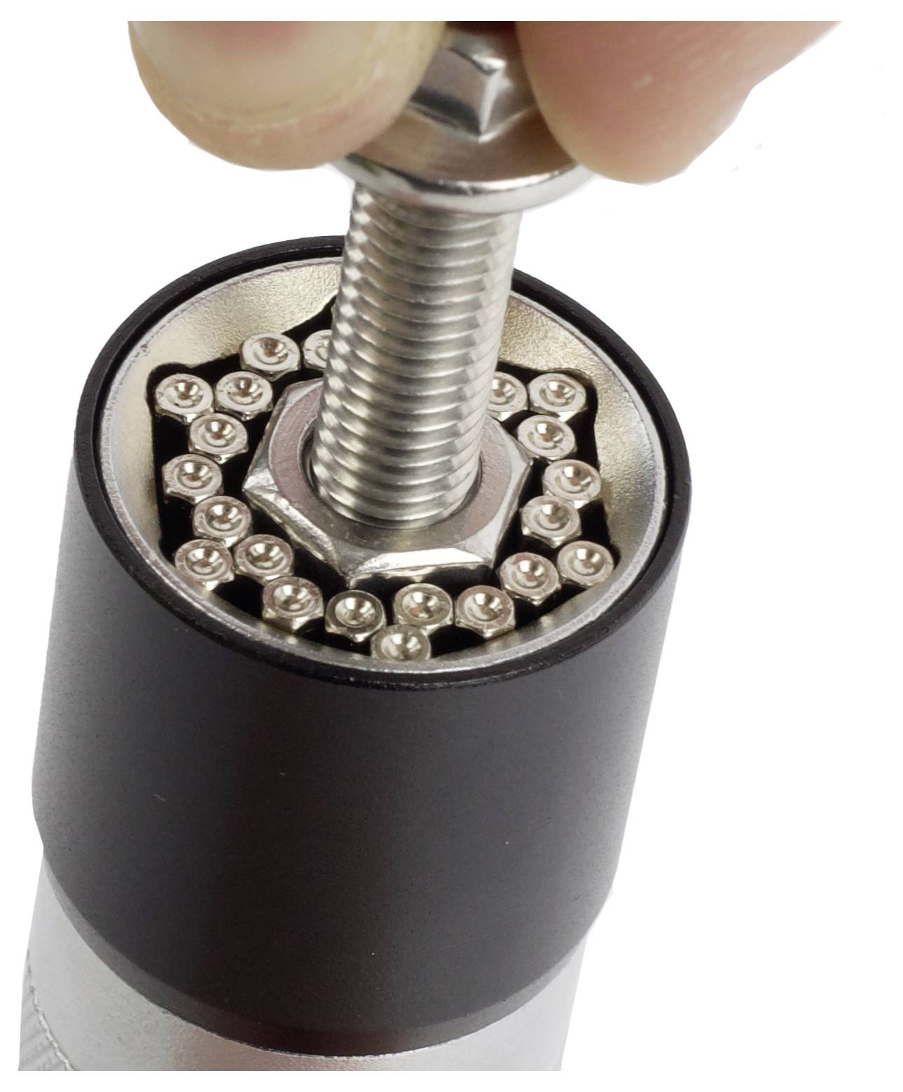 Ein universelles Steckschlüssel-Werkzeug mit sechseckigen Stiften passt sich an, um einen großen Metallbolzen zu greifen und zu halten, wobei sein adaptiver Mechanismus demonstriert wird.