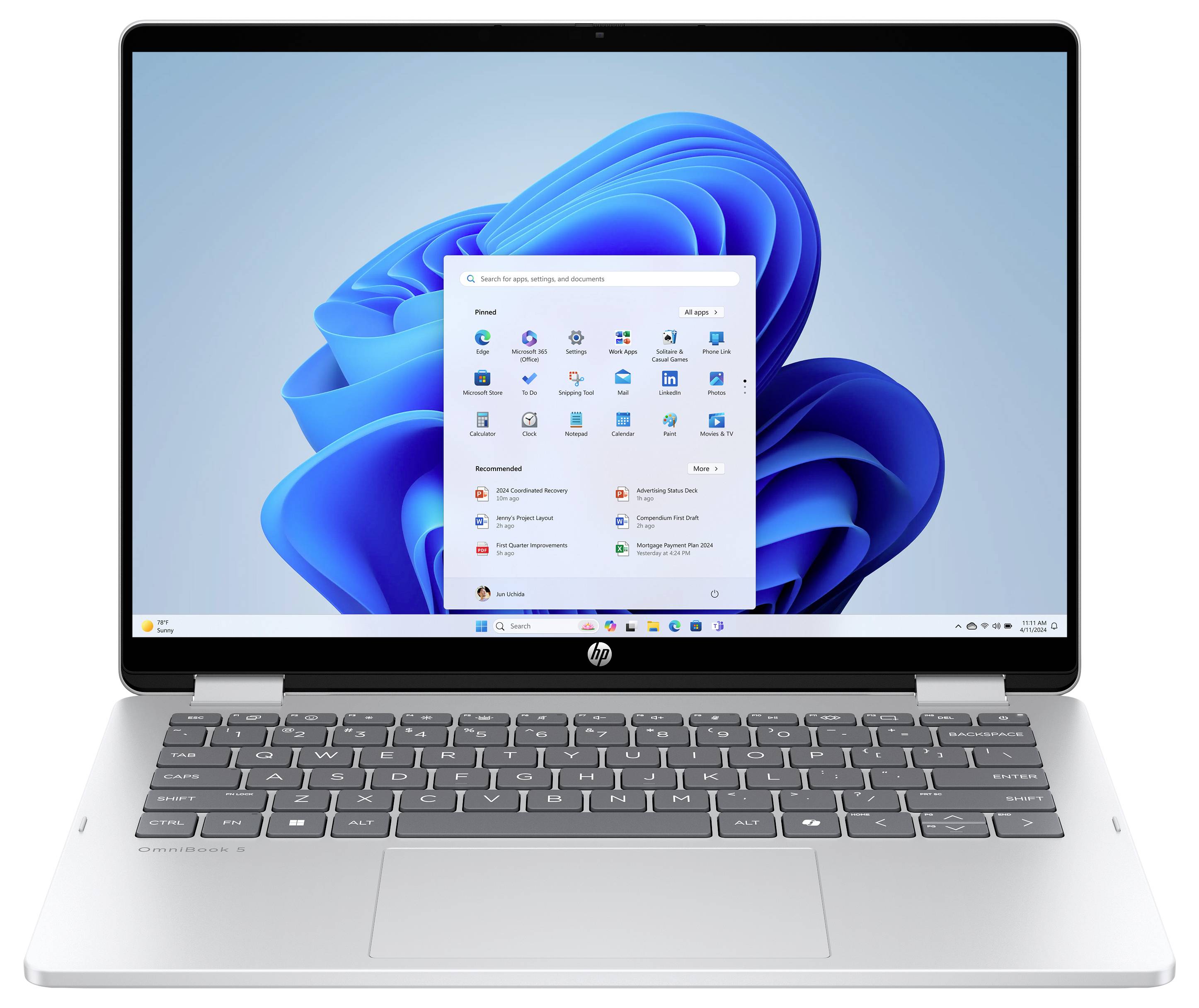 Ein Laptop mit Windows 11-Startmenü auf seinem Bildschirm, das verschiedene App-Symbole und Einstellungen zeigt. Der Laptop hat ein silbernes Gehäuse und eine schwarze Tastatur.