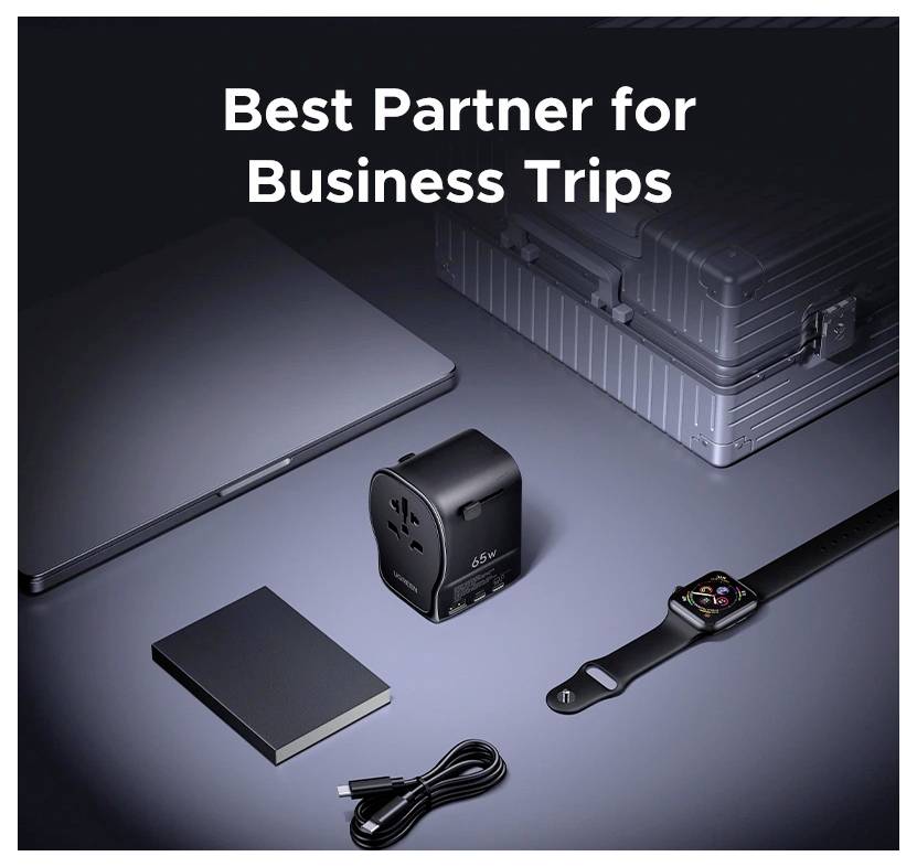 Ein reisefreundlicher Stromanschlussadapter mit USB-Anschlüssen neben einem geschlossenen Laptop, einer Smartwatch, einem Koffer und einem Ladekabel unter dem Text „Bester Partner für Geschäftsreisen