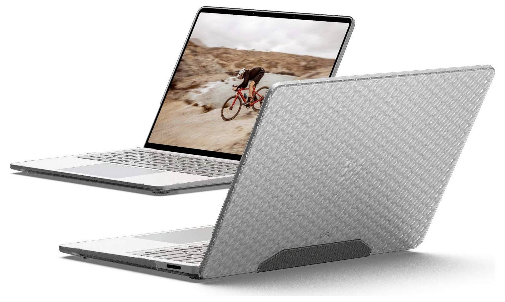 Zwei Laptops: einer zeigt eine Person, die in einer Wüste radelt, der andere mit einem strukturierten grauen Gehäuse, was Abenteuer und Langlebigkeit symbolisiert.