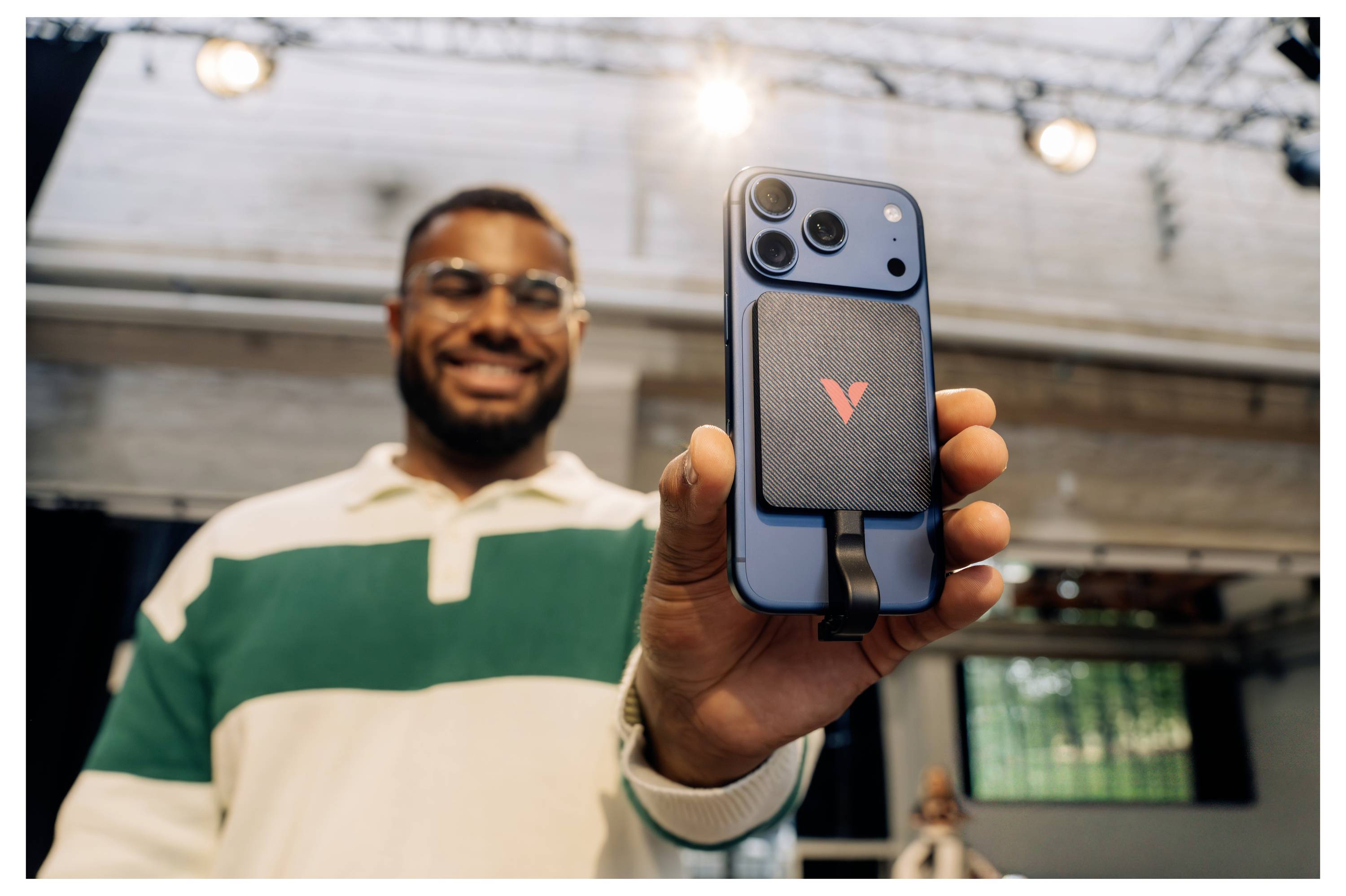 Ein lächelnder Mann hält ein blaues Smartphone mit einem 