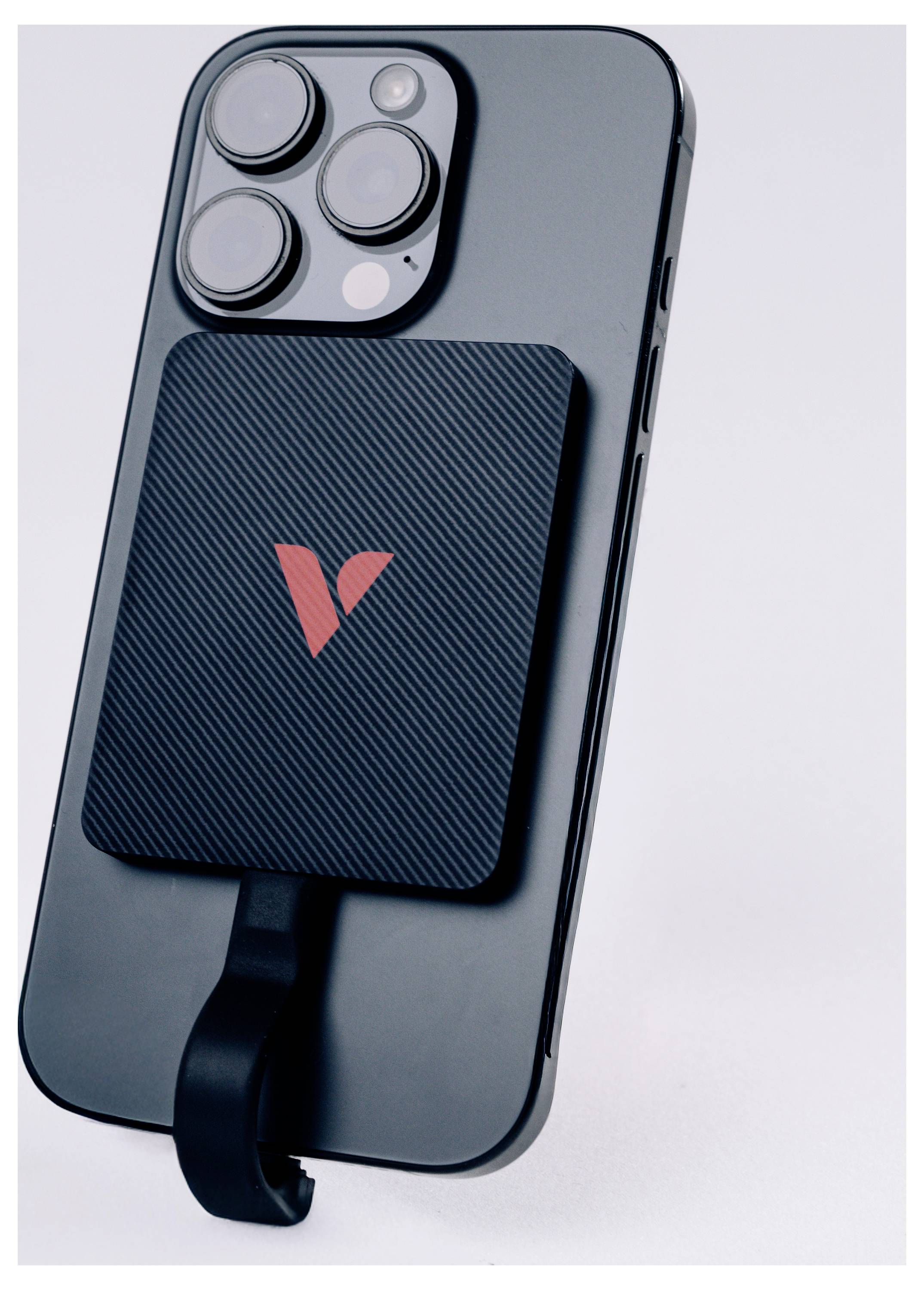 Magnetisches kabelloses Ladegerät auf der Rückseite eines dunklen Smartphones mit Triple-Kamera-Array.