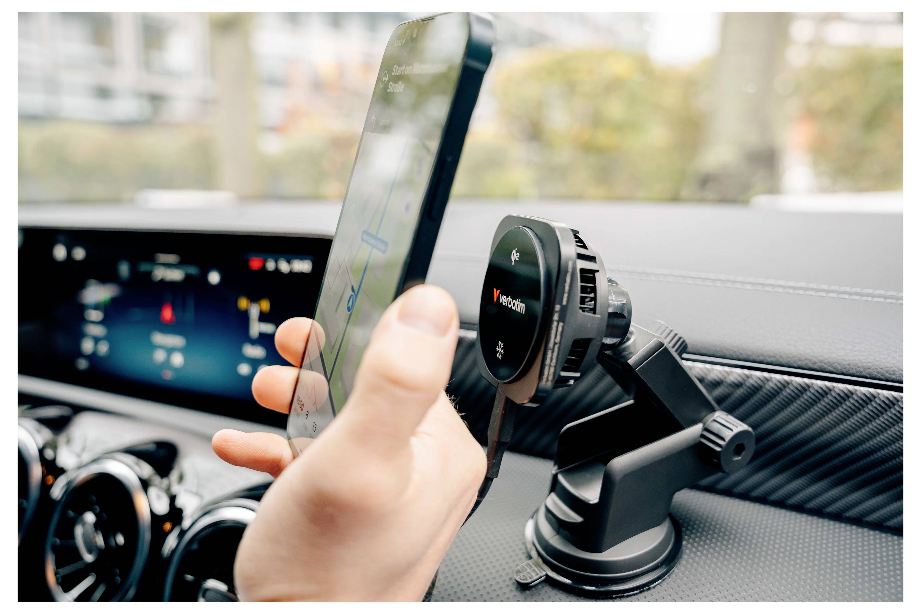 Hand, die ein Smartphone in der Nähe einer Smartphone-Halterung im Auto-Armaturenbrett hält, zeigt die Navigation im Auto oder das Setup.