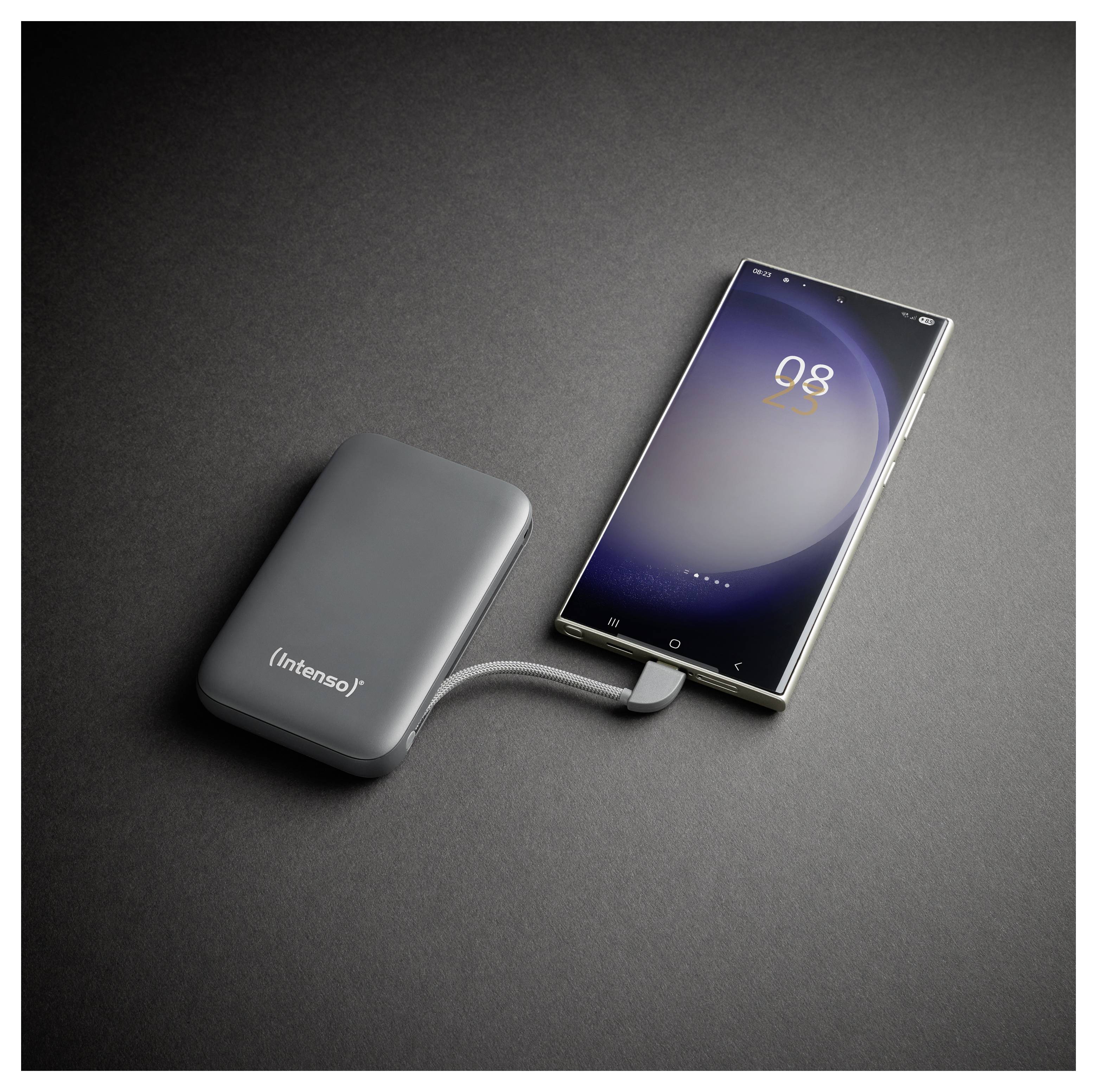 Ein Smartphone, das über ein kurzes Kabel mit einer tragbaren Powerbank verbunden ist, beide auf einer dunklen Oberfläche. Der Telefonbildschirm zeigt 