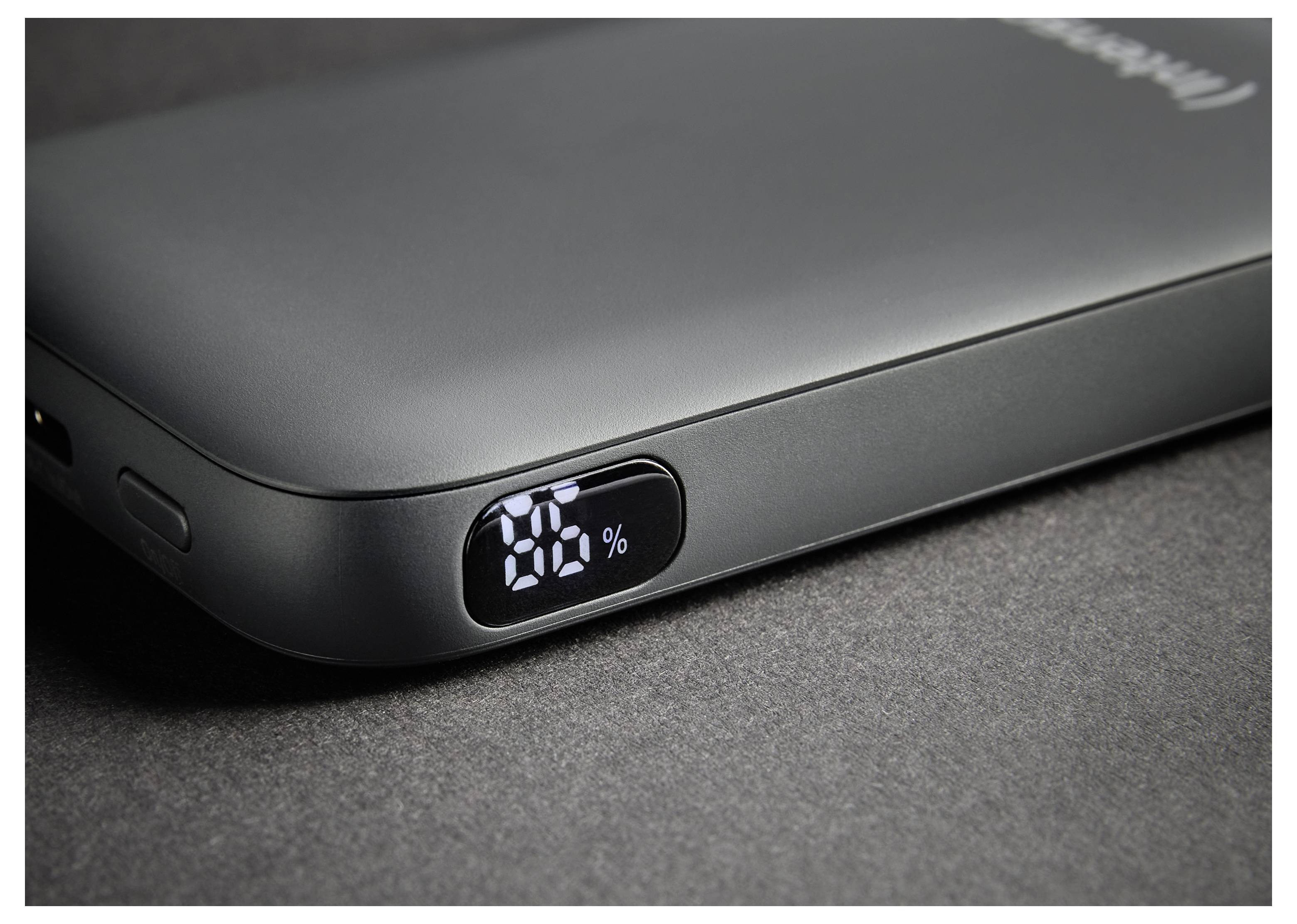 Ein schwarzes tragbares Powerbank auf einer dunklen Oberfläche zeigt „76 %