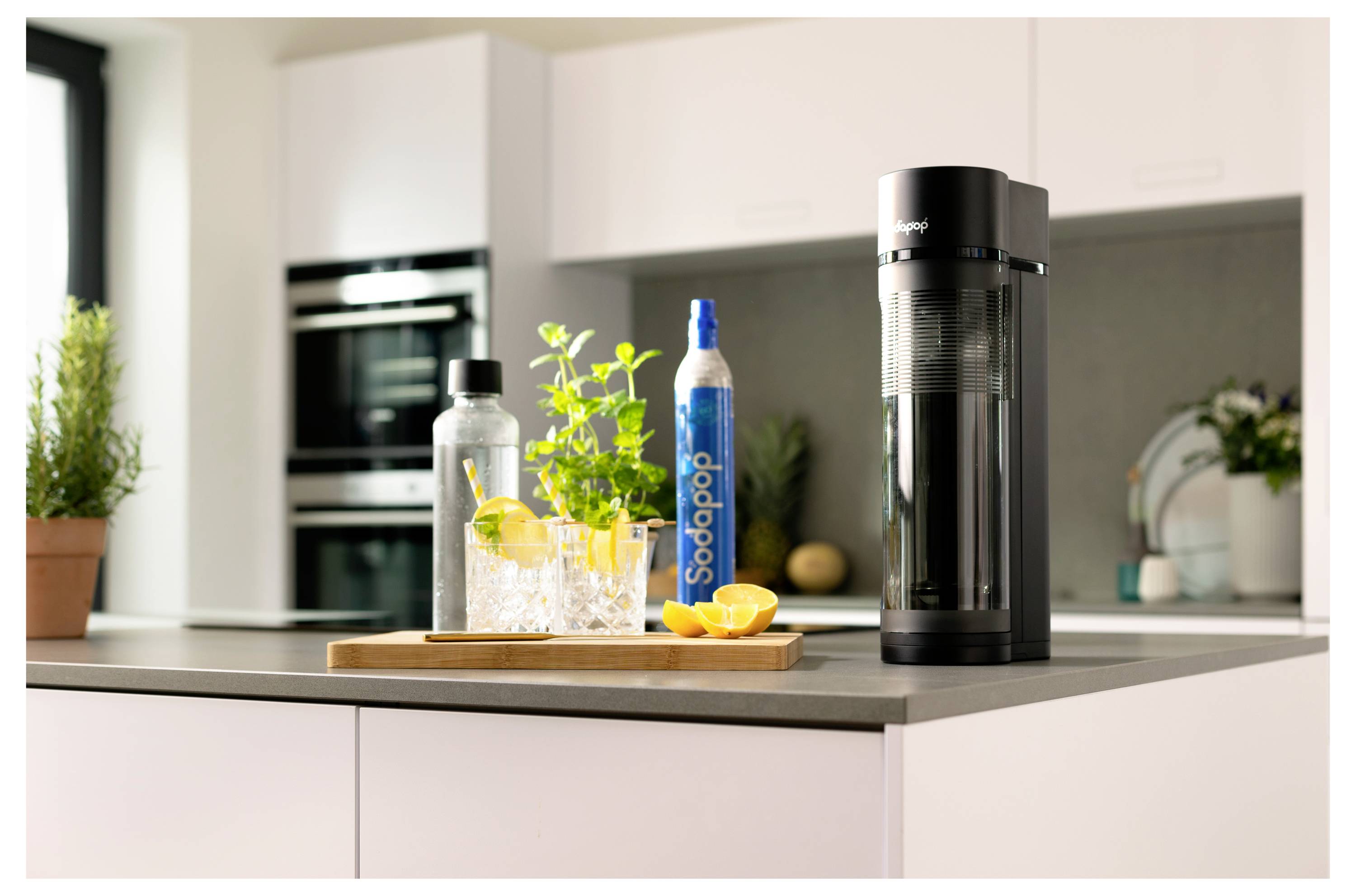 Eine Küchentheke mit einem Wassersprudler, einer Flasche mit der Aufschrift „Sodapop
