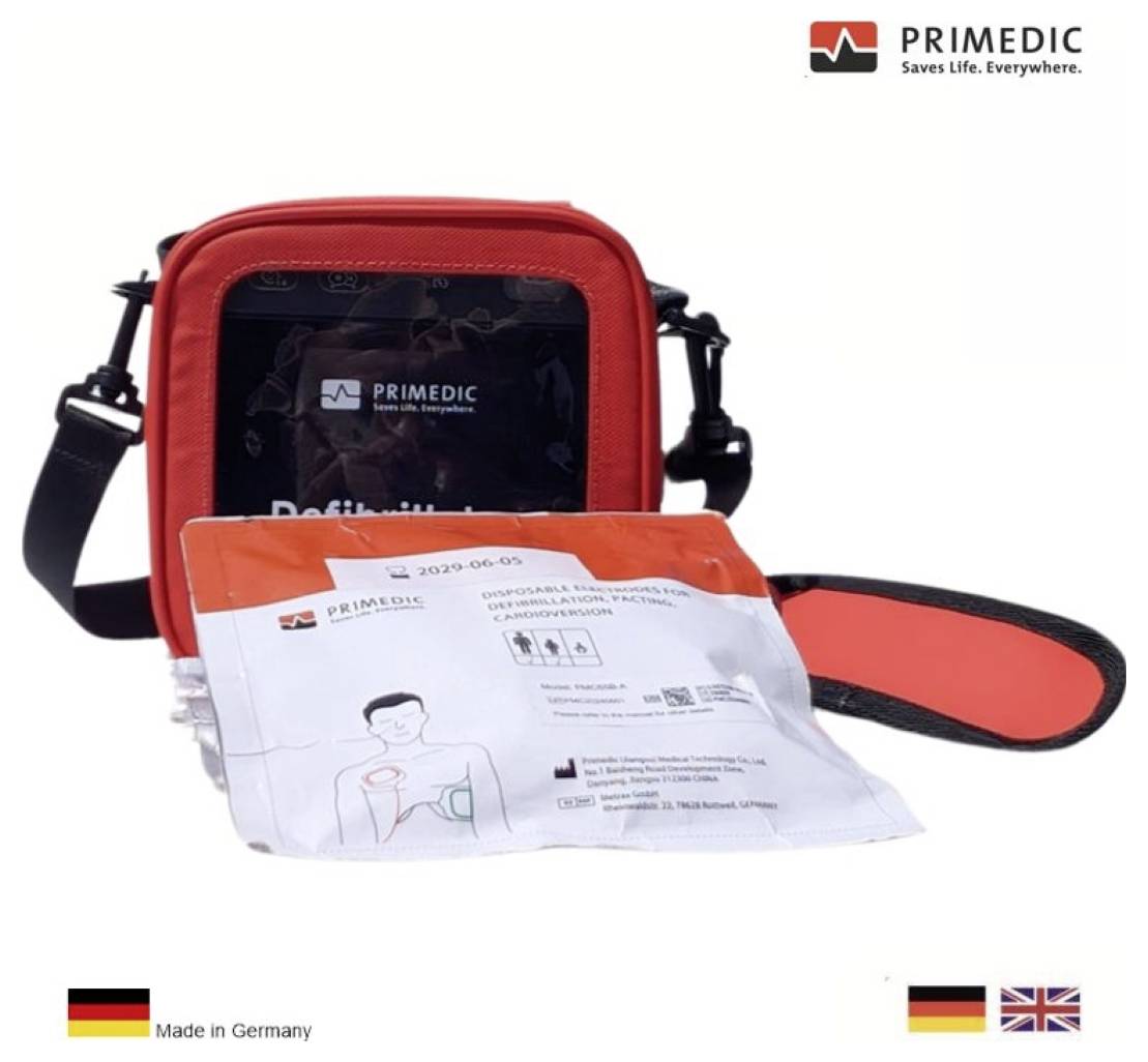 Ein Defibrillator-Set mit rotem Tragekoffer und einem Anleittungspaket. Der Satz „PRIMEDIC Saves Life. Everywhere.